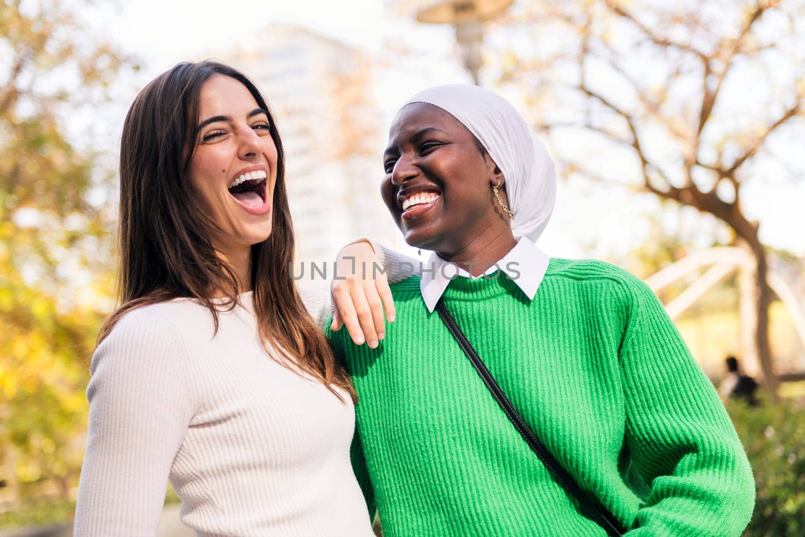 multiracial couple of two young women laughing and having fun, concept of friendship and happiness