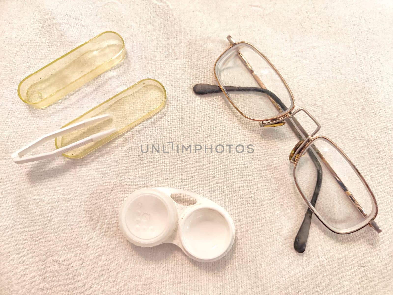 A set for contact lenses with a container, forceps, glasses. The concept of correcting myopia. Contact lens care, cleaning, health. Background, copy space by keleny
