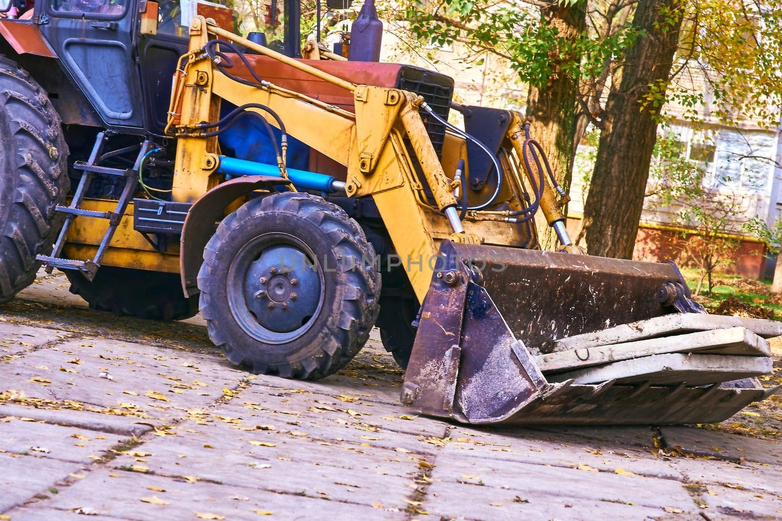 Excavator bulldozer loads old concrete slabs on road repair by jovani68