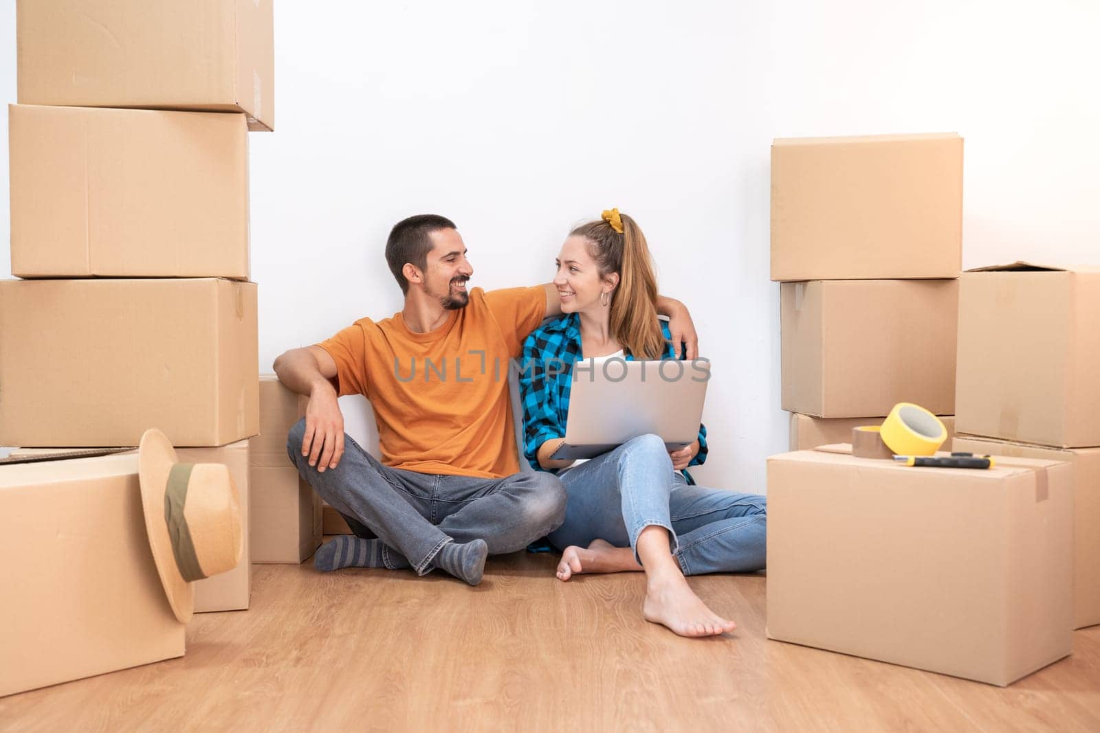 Household Move. Attractive couple with moving boxes becoming independent and opening a new home. by PaulCarr