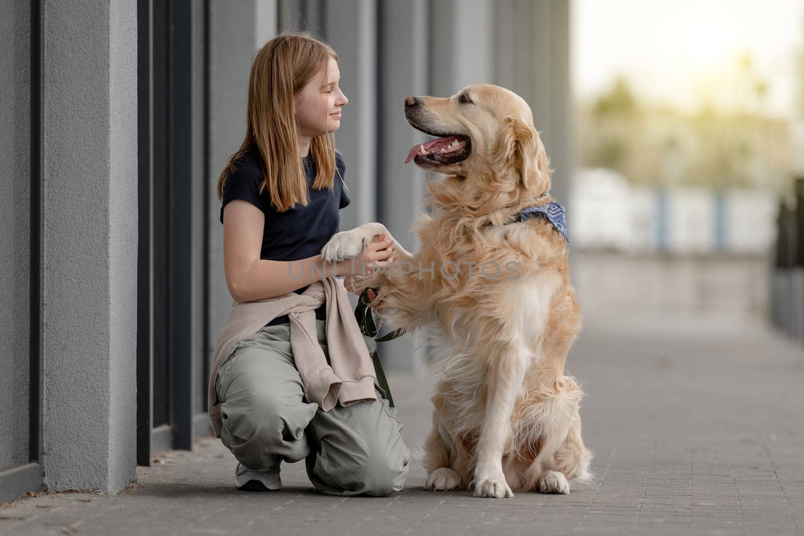 Girl With Golden Retriever Sits Playing Outside