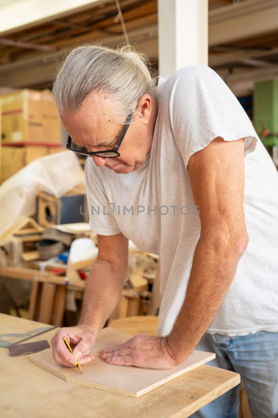 Carpenter working on wood craft at workshop producing wooden furniture. High quality photo