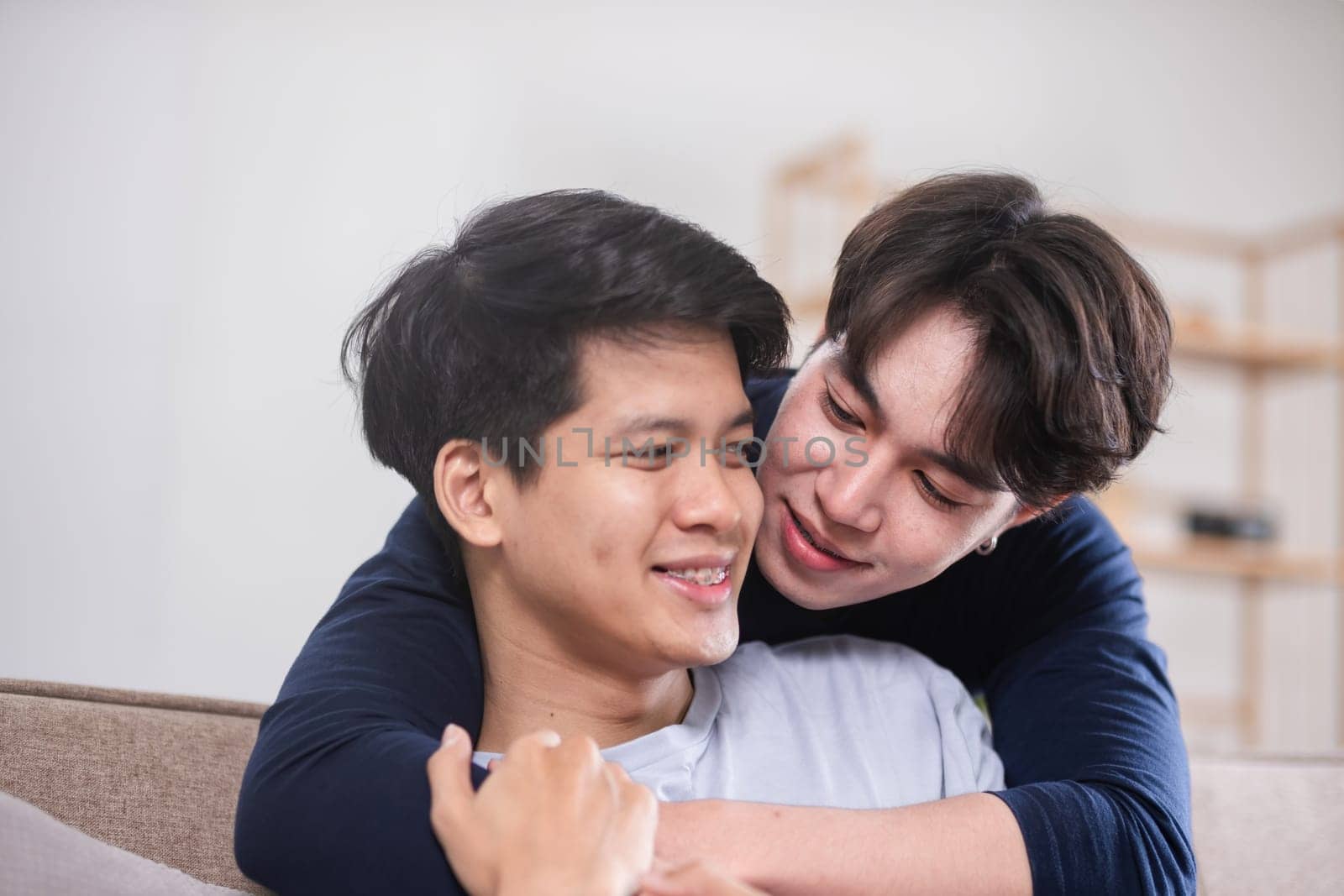 A male-male couple spends their free time happily doing holiday activities together, embracing each other and taking selfies together in the living room..