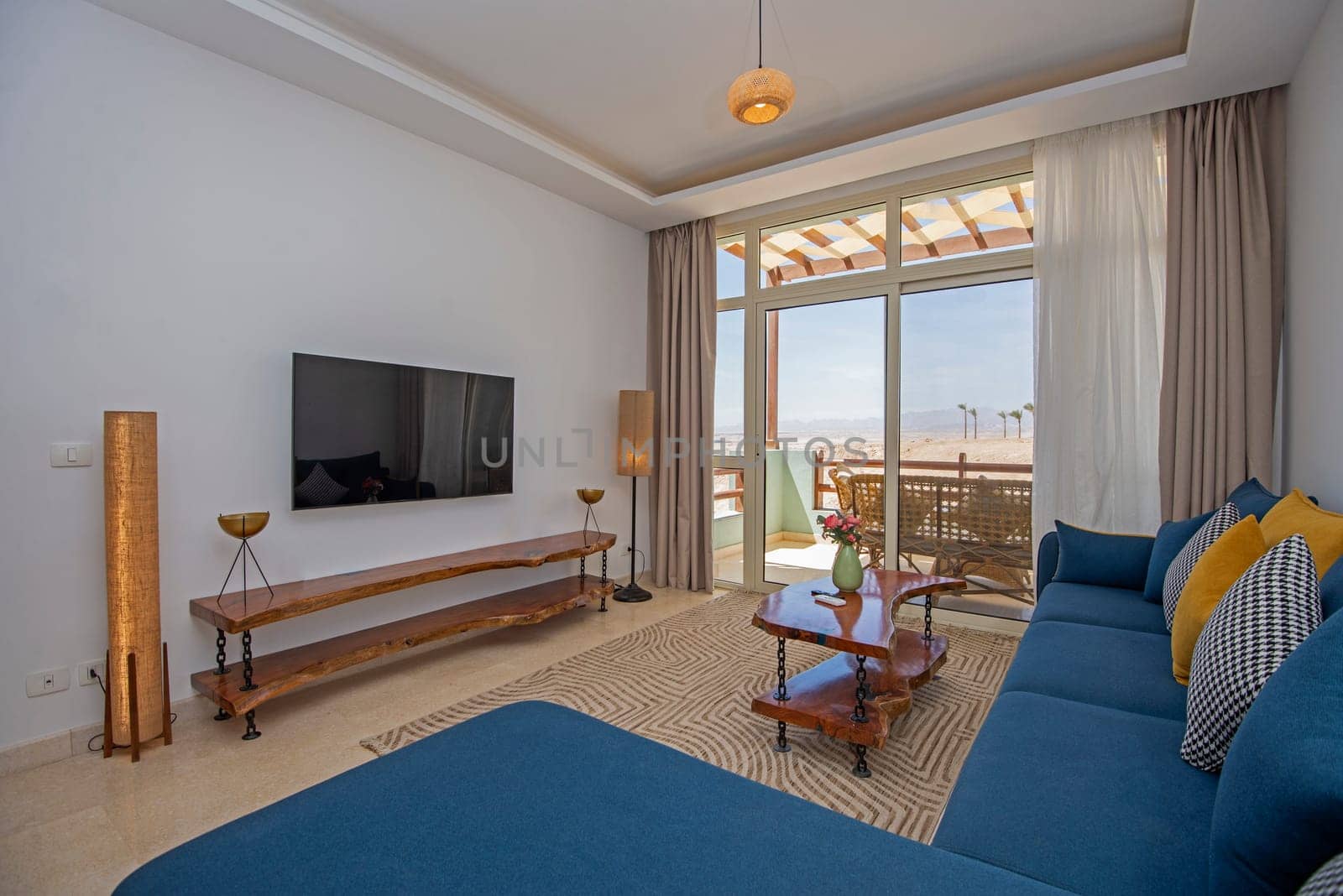 Living room lounge area in luxury apartment show home showing interior design decor furnishing with balcony terrace