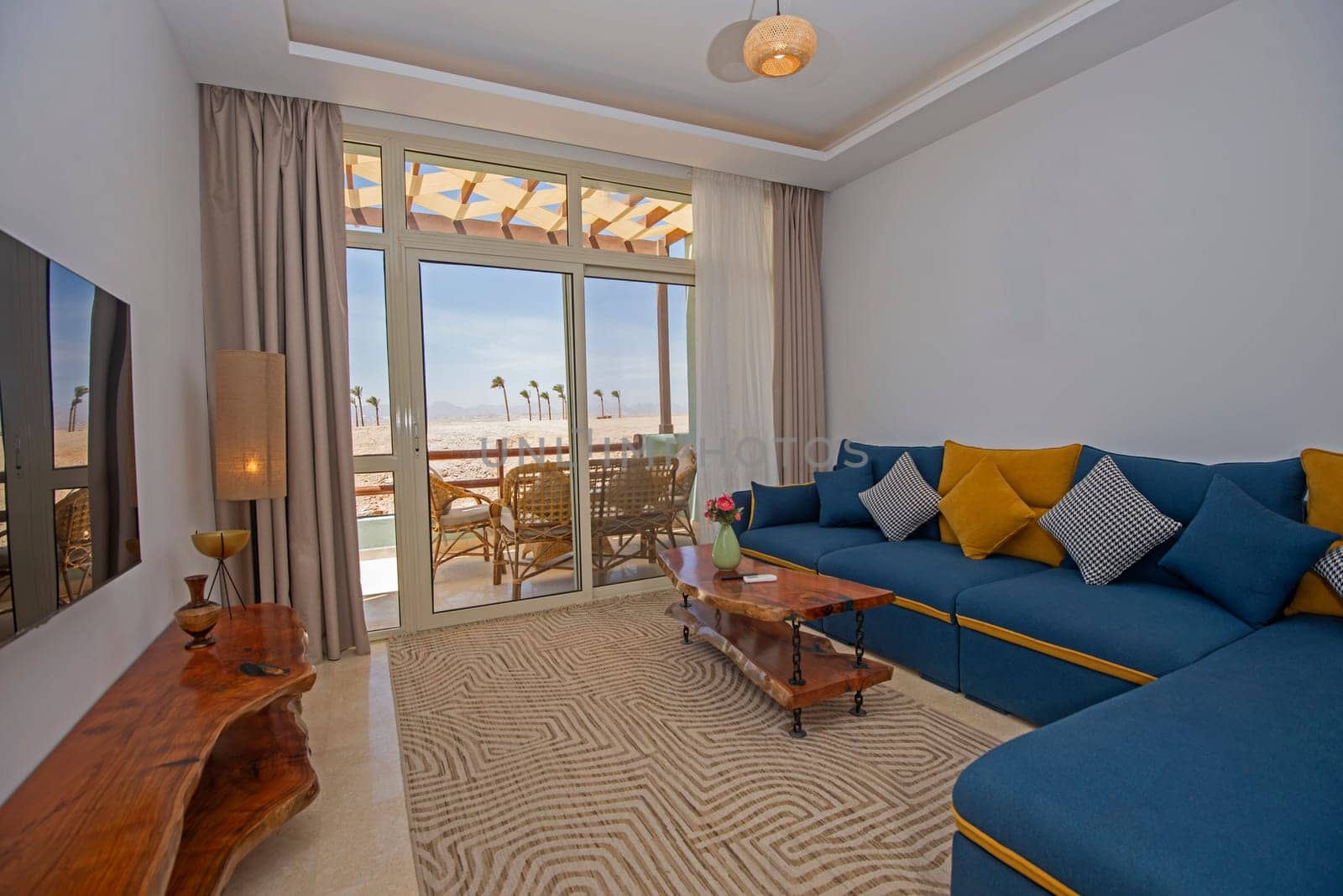 Living room lounge area in luxury apartment show home showing interior design decor furnishing with balcony terrace