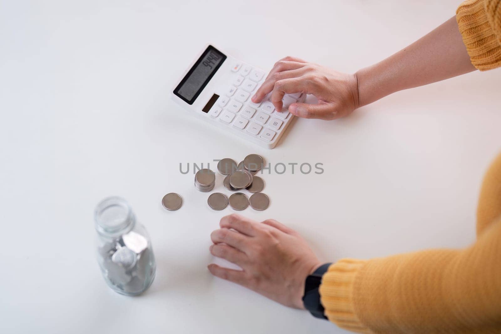 Money saving concept, accountant counting and calculating annual financial budget. Woman handling expenses, savings, bill, receipt by nateemee