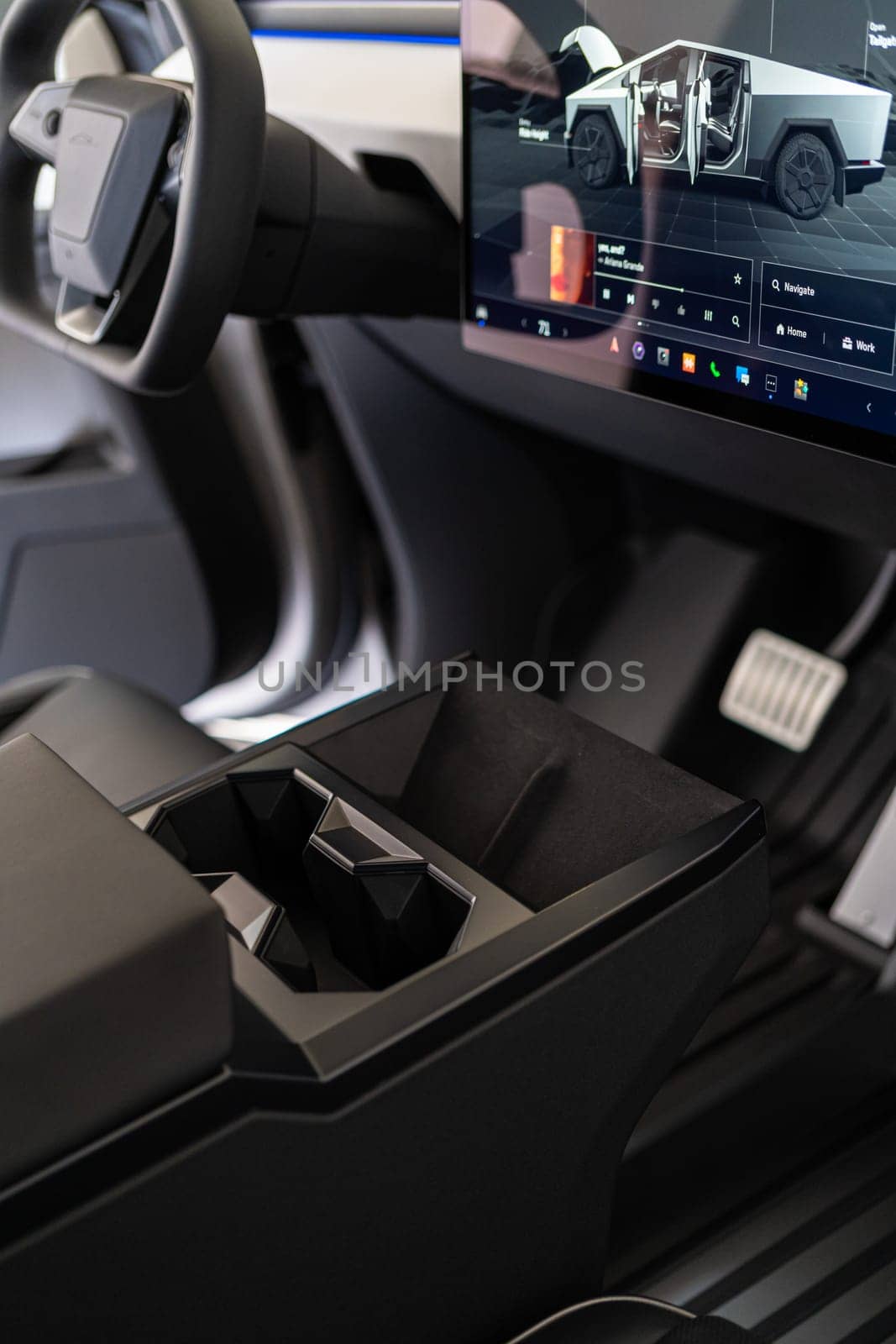 Denver, Colorado, USA-May 5, 2024-This image offers an interior view of the Tesla Cybertruck, highlighting the central console with its geometric cup holders and the prominent touch screen display that controls various vehicle functions, embodying Tesla modern design ethos.