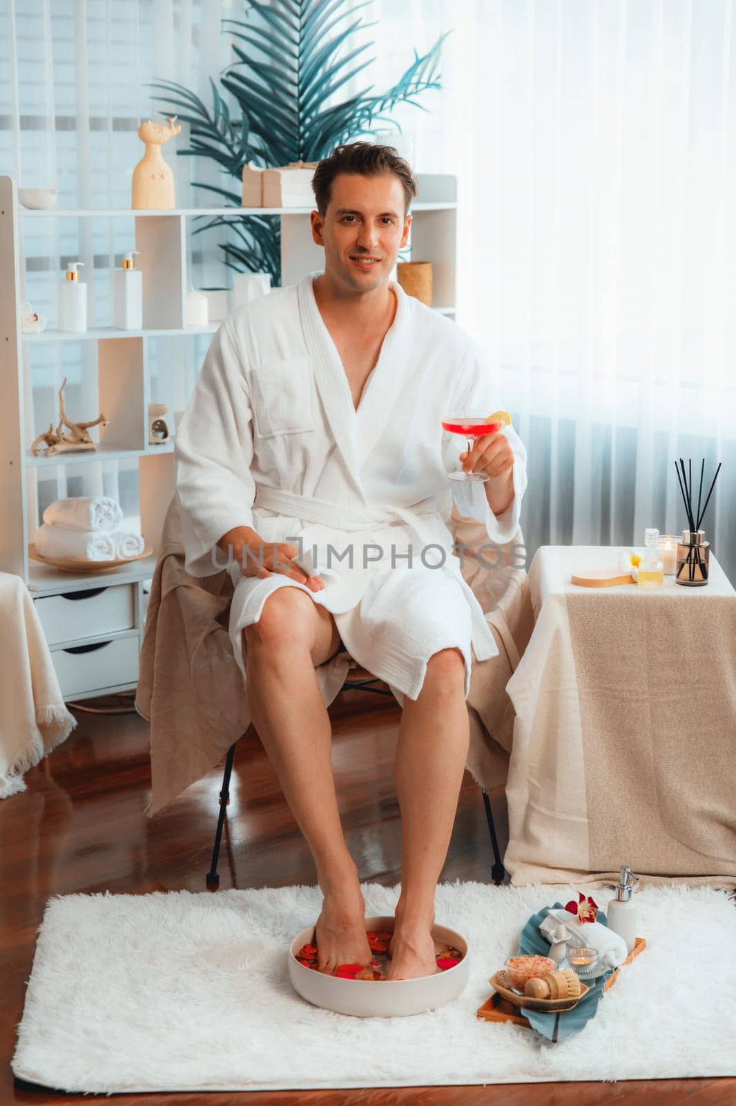 Couple wearing bathrobe relaxing with drinks in luxurious hotel spa. Quiescent by biancoblue