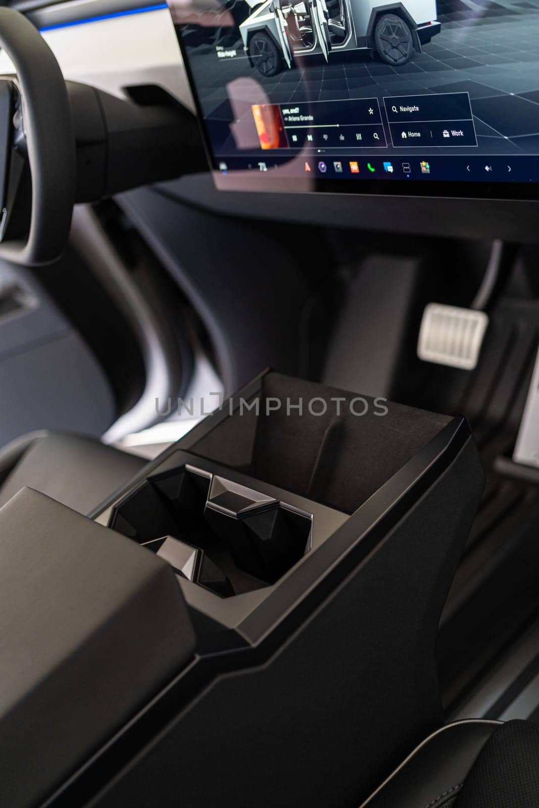 Denver, Colorado, USA-May 5, 2024-This image offers an interior view of the Tesla Cybertruck, highlighting the central console with its geometric cup holders and the prominent touch screen display that controls various vehicle functions, embodying Tesla modern design ethos.