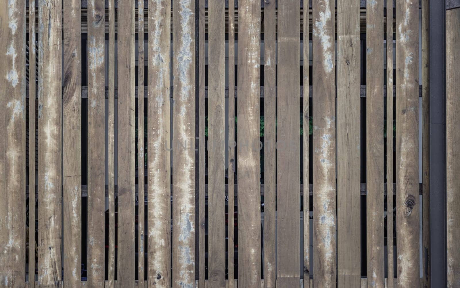 Textural background of wooden panels an old fence with a clear pattern of wood. A row evenly spaced rough brown timber planks used as a garden fence, Old natural wooden plank background texture, Space for text, Selective focus.