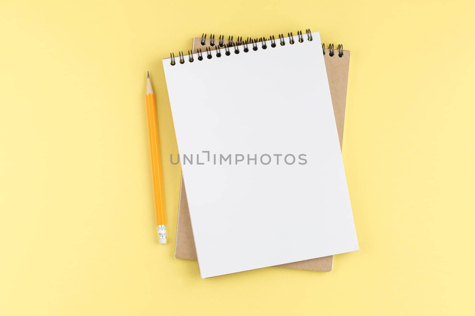 Spiral notebook with orange pencil. Top view. by alexxndr