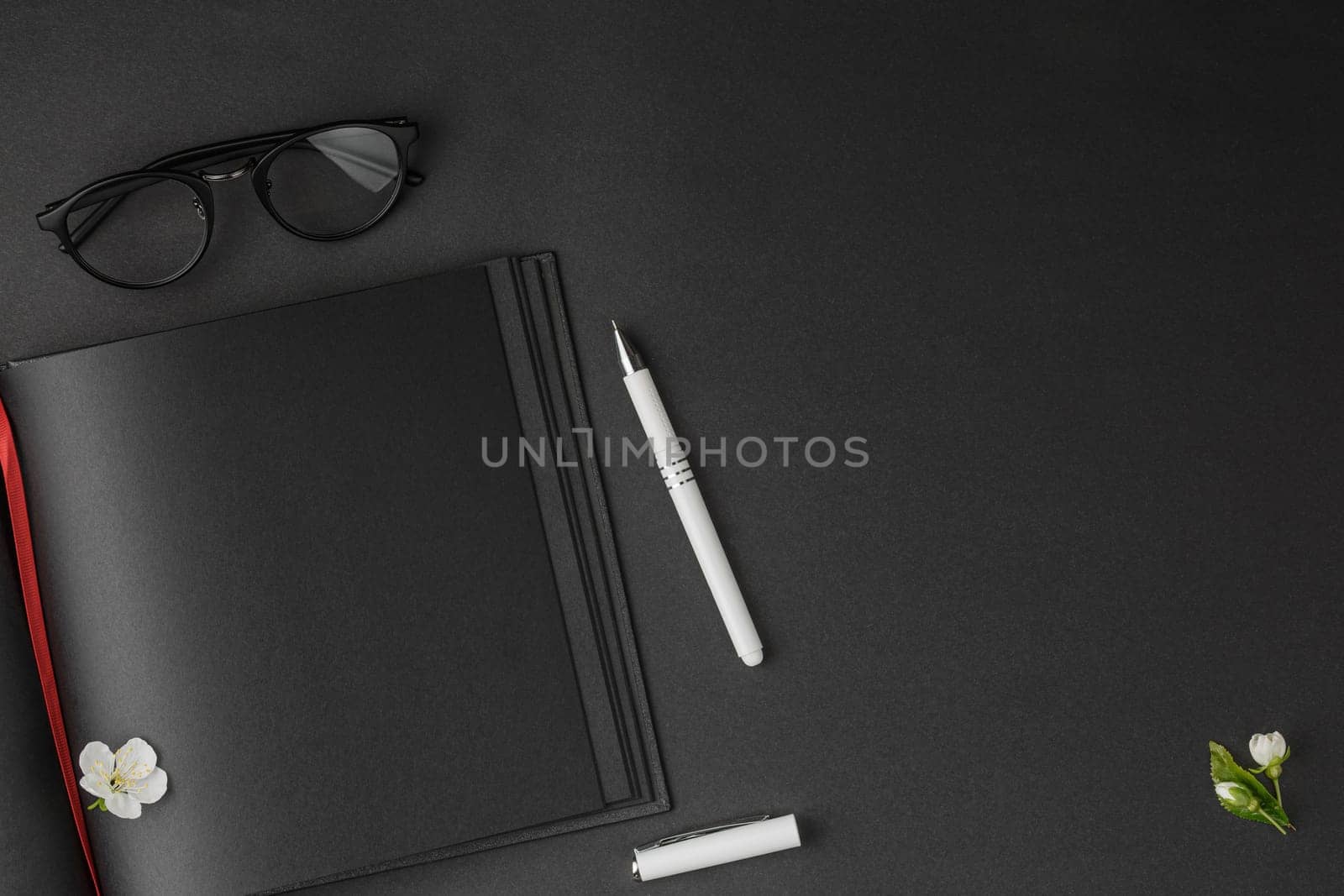 Notepad, pen and glasses with white flowers. by alexxndr