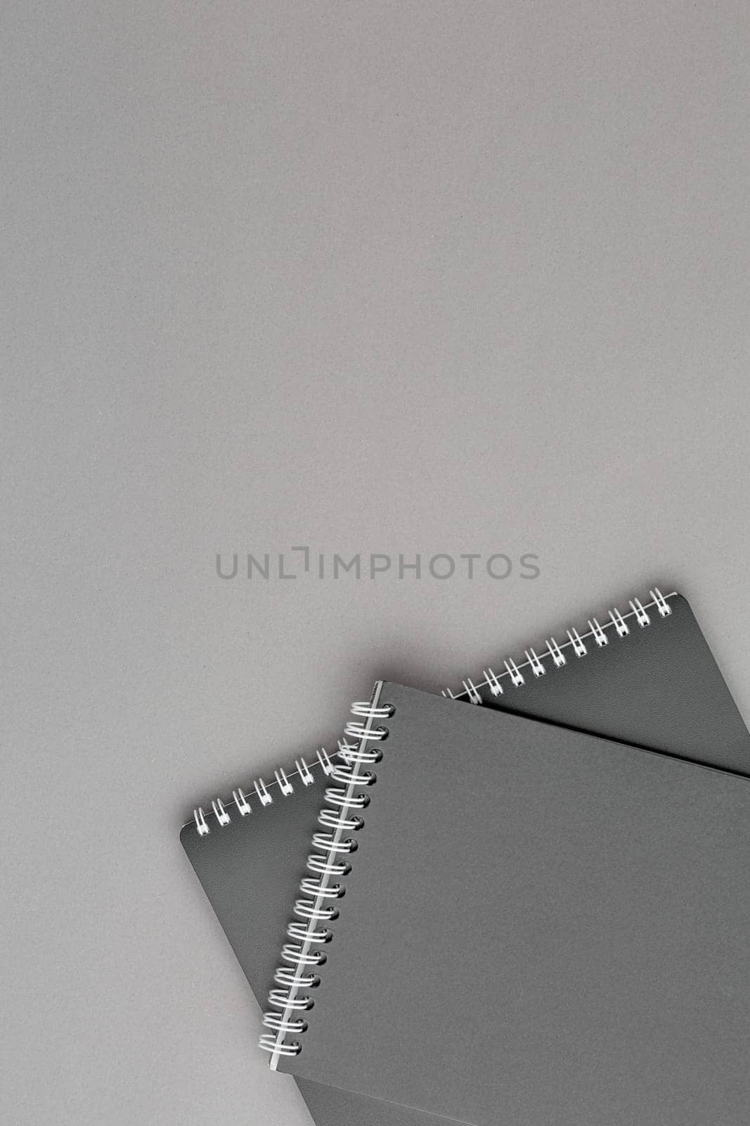 Spiral notebook with black paper sheets on gray isolated background. Top view close up.