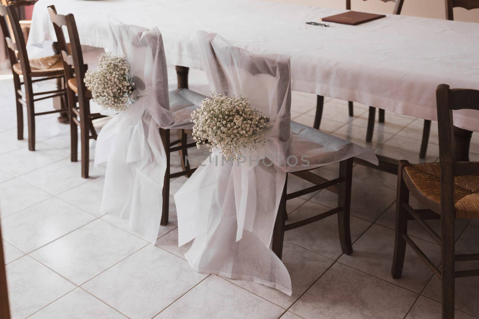 Wedding chairs decorated with white cloth and gypsophila flowers