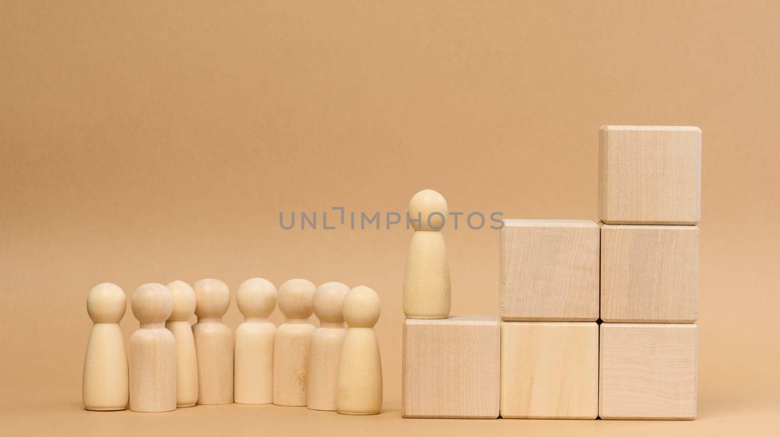 Wooden figures of men on a ladder made of blocks. The concept of career advancement, starting at work, achieving goals.