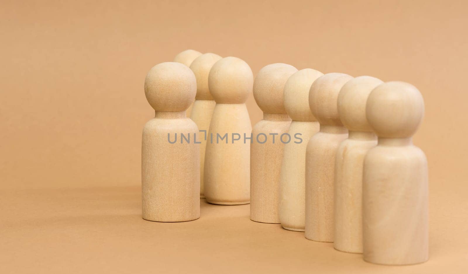 A row of wooden figures and one standing in front. Recruitment concept, talented employee