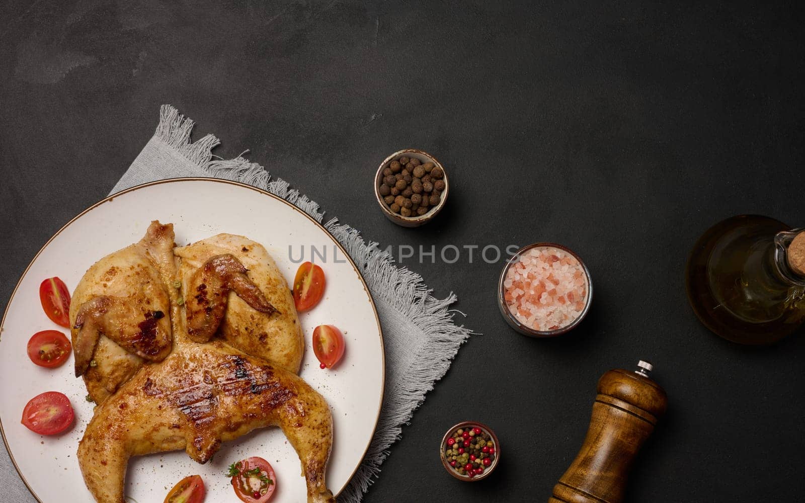 Whole fried chicken with spices in a white round plate on the table by ndanko