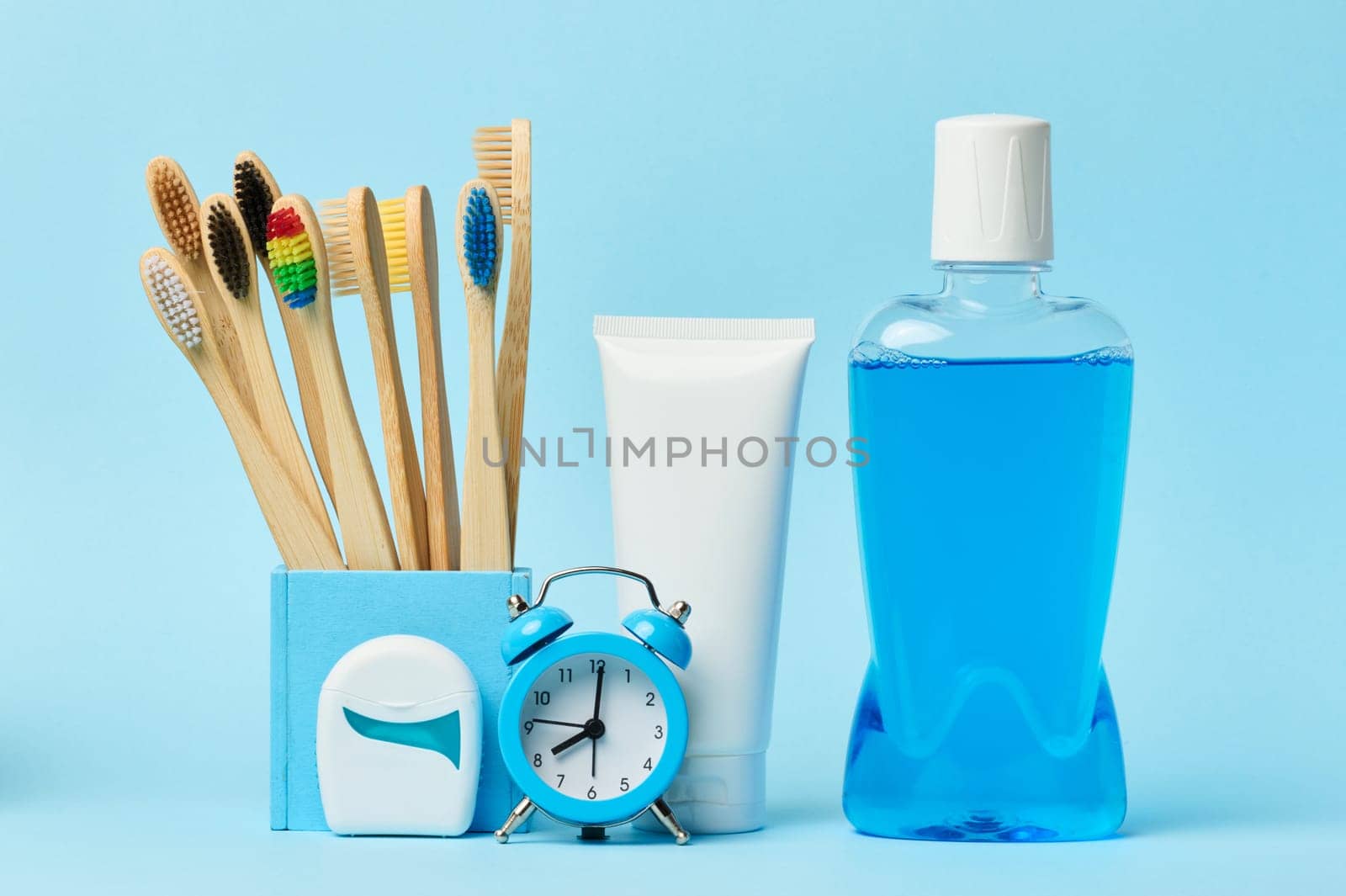 Mouthwash and toothpaste tube blue background, morning routine for oral hygiene by ndanko