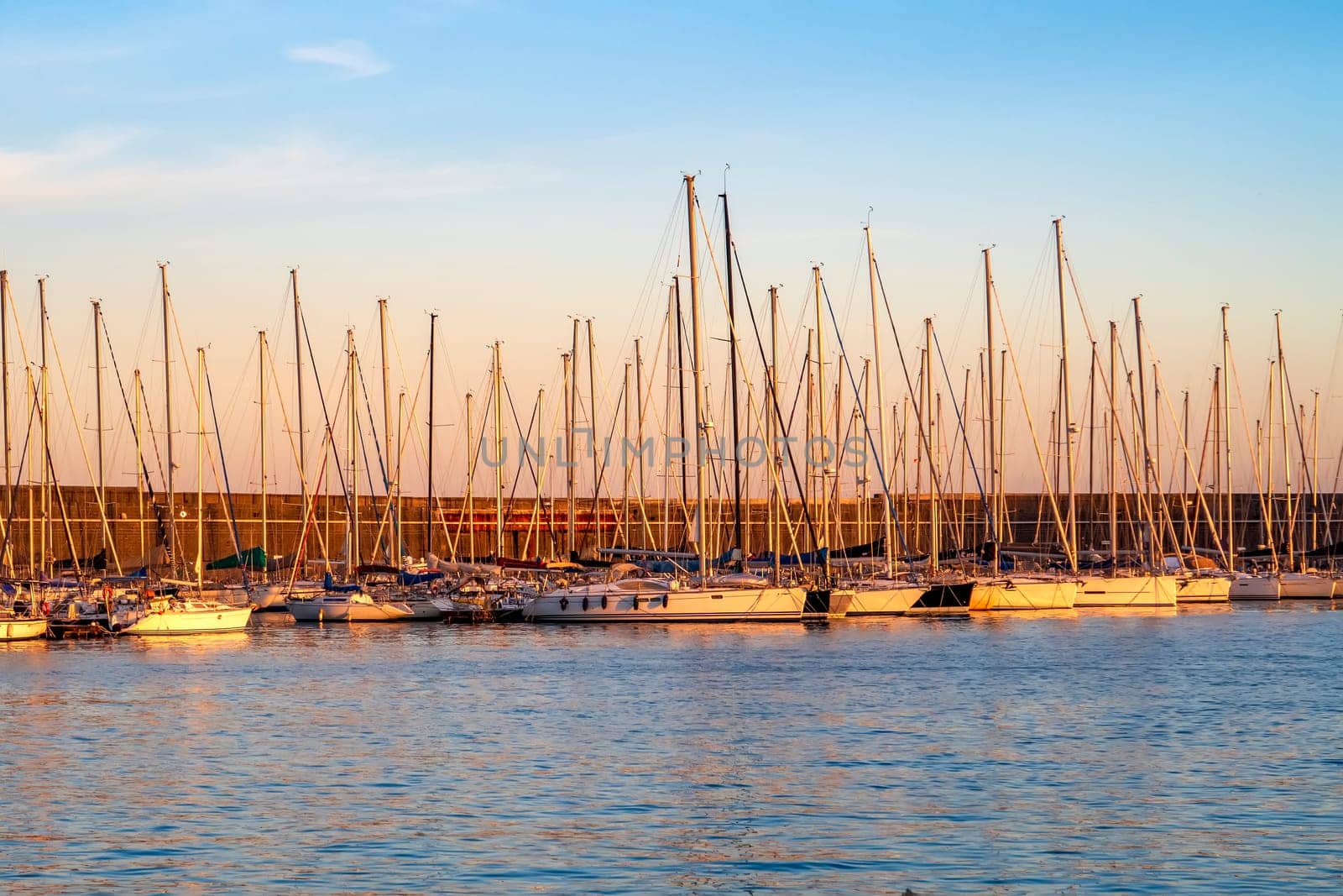 Yachts and boats at sunset in a marina. Sunset at port.  by EdVal
