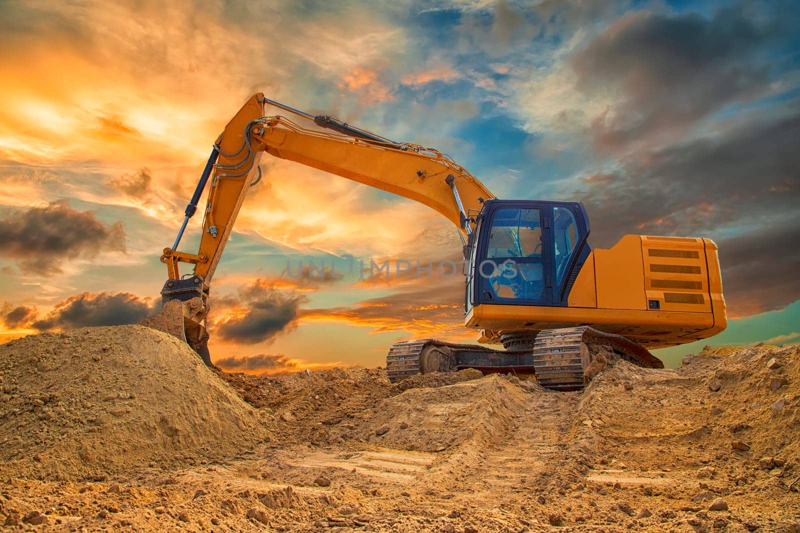 A stopping yellow excavator at an incredibly colorful sunset