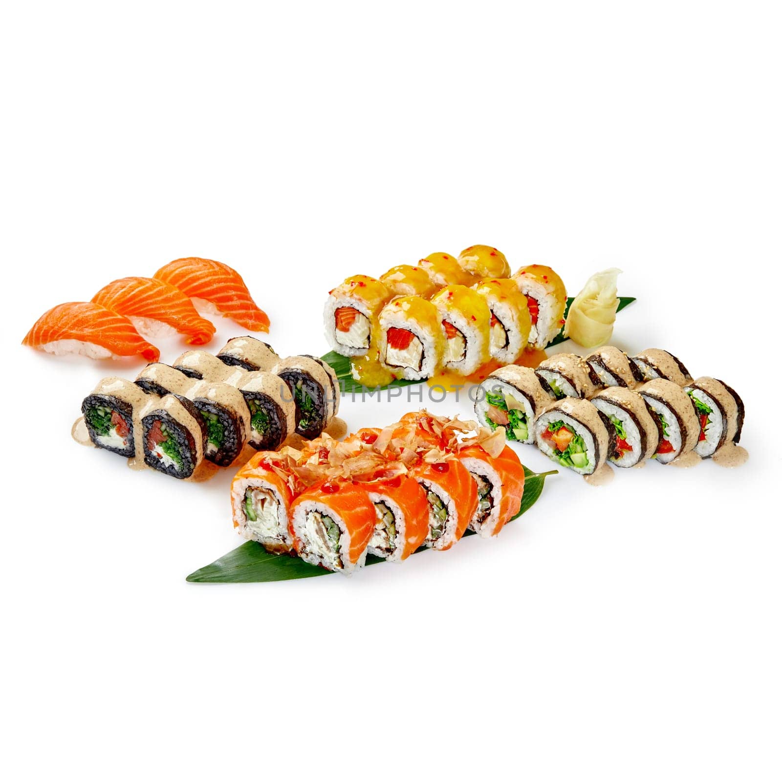 Set for company of traditional Japanese vegetarian futomaki, uramaki and nigiri sushi with salmon, eel and shrimp dressed with spicy sauces, on bamboo leaves with wasabi and ginger isolated on white