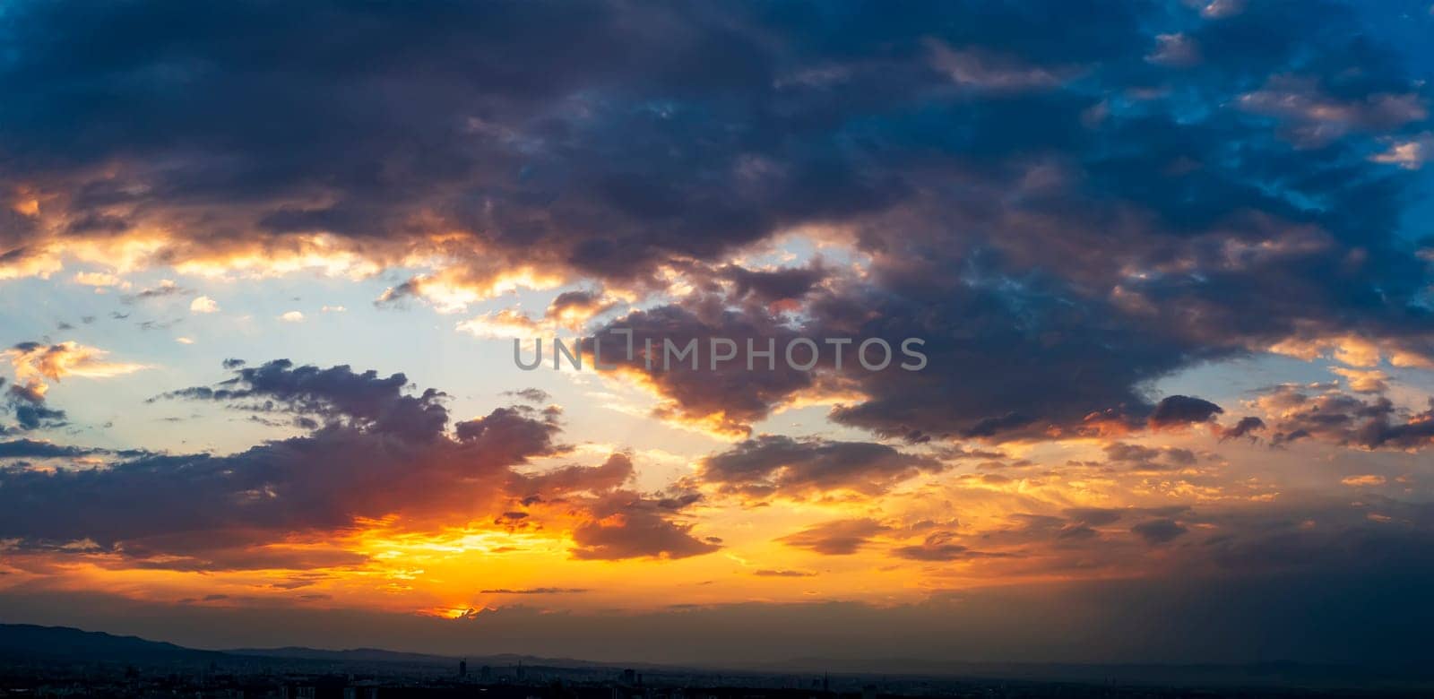 Dramatic colorful clouds in the sunset sky. Panoramic view. Natural background.