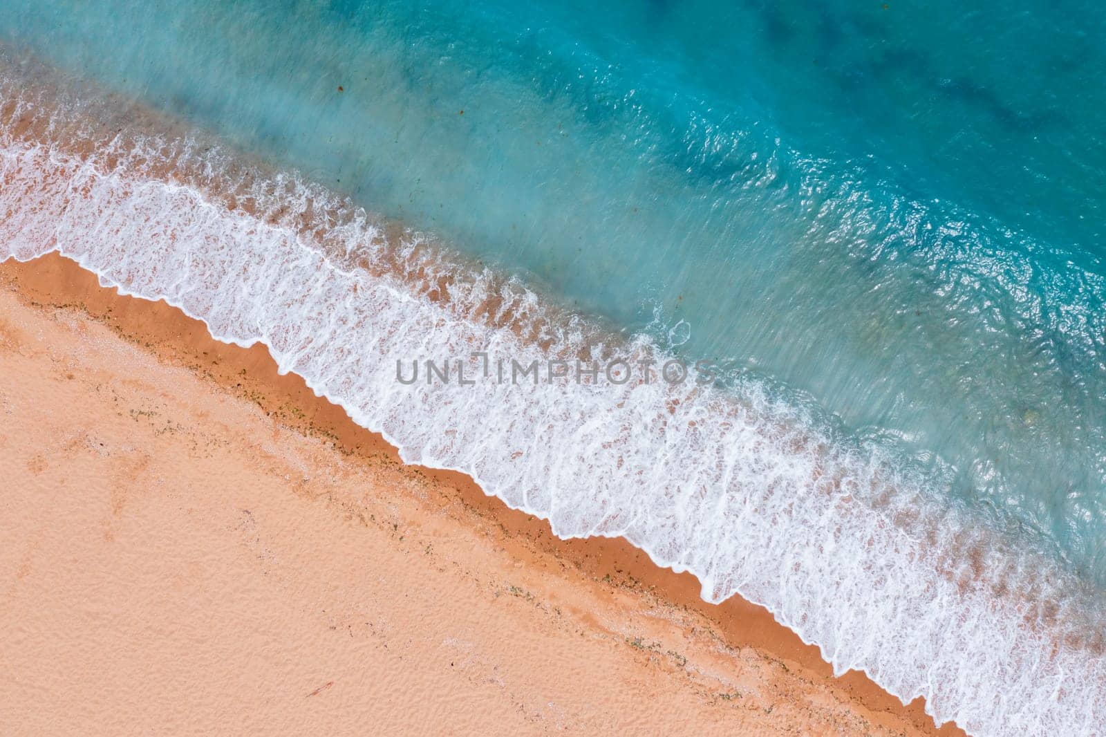 Aerial drone overhead view of beautiful waves on sand. by EdVal