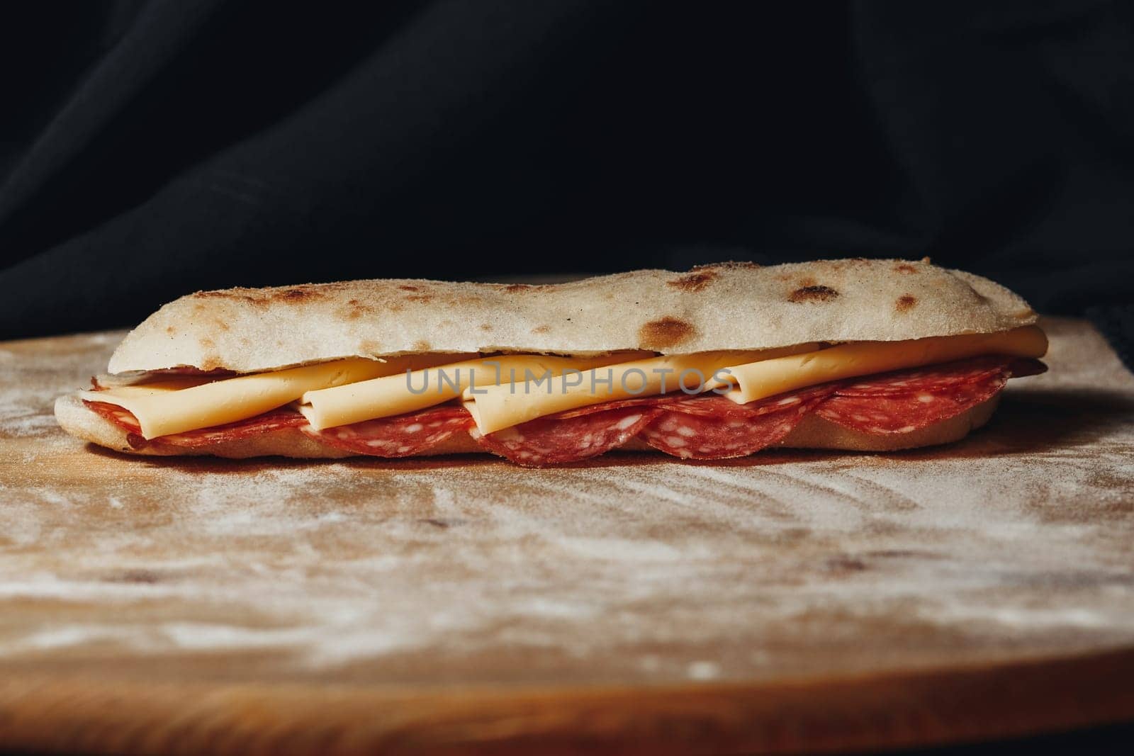 Artisanal Pepperoni andA close-up view of a freshly made pepperoni and cheese sandwich on rustic bread, resting on wood. Cheese Sandwich on a Wooden Cutting Board. High quality photo