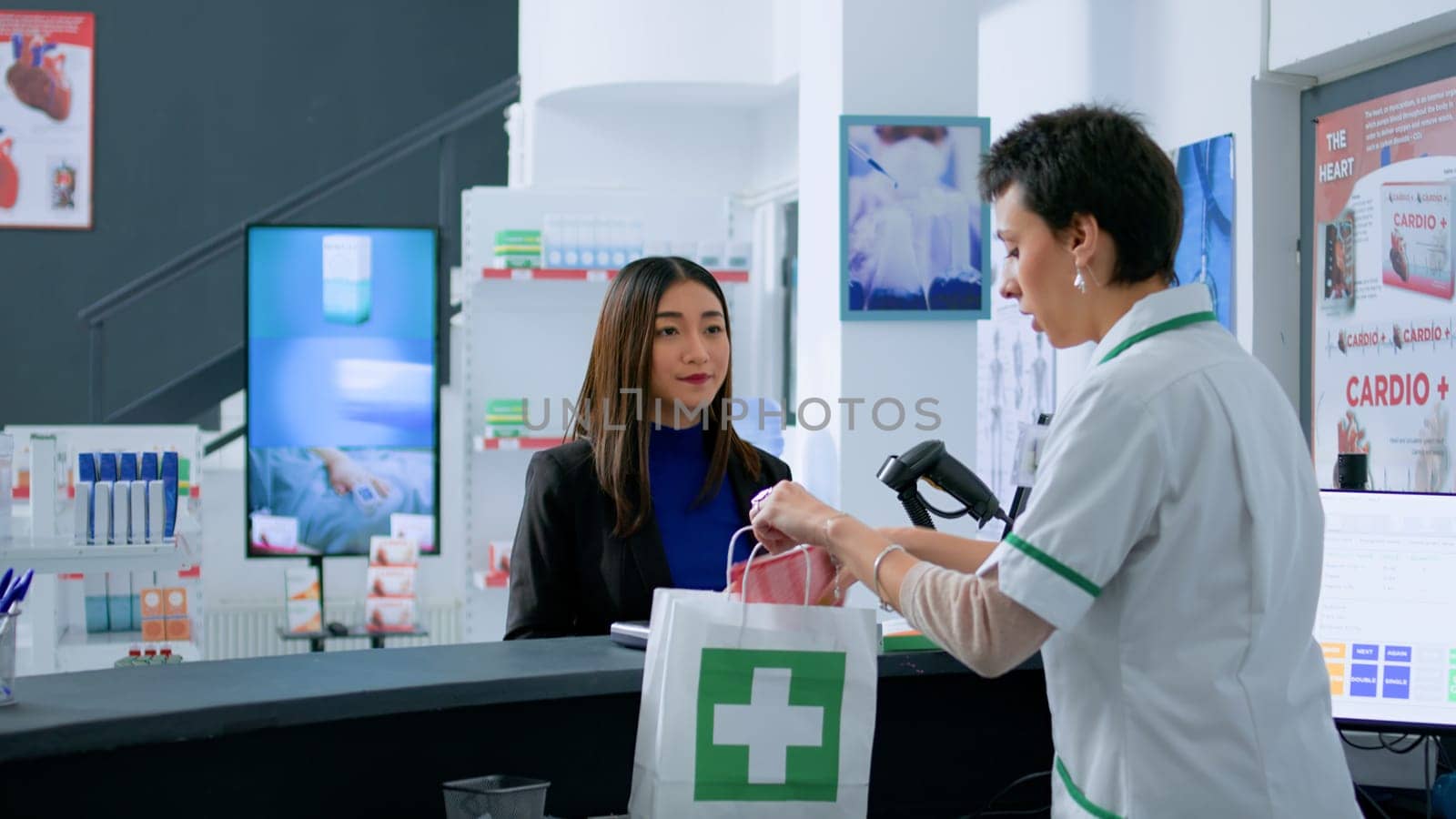 Senior pharmacy assistant helping asian client pick ideal medicinal products for illness easing before reaching drugstore counter. Customer buying supplements and vitamins