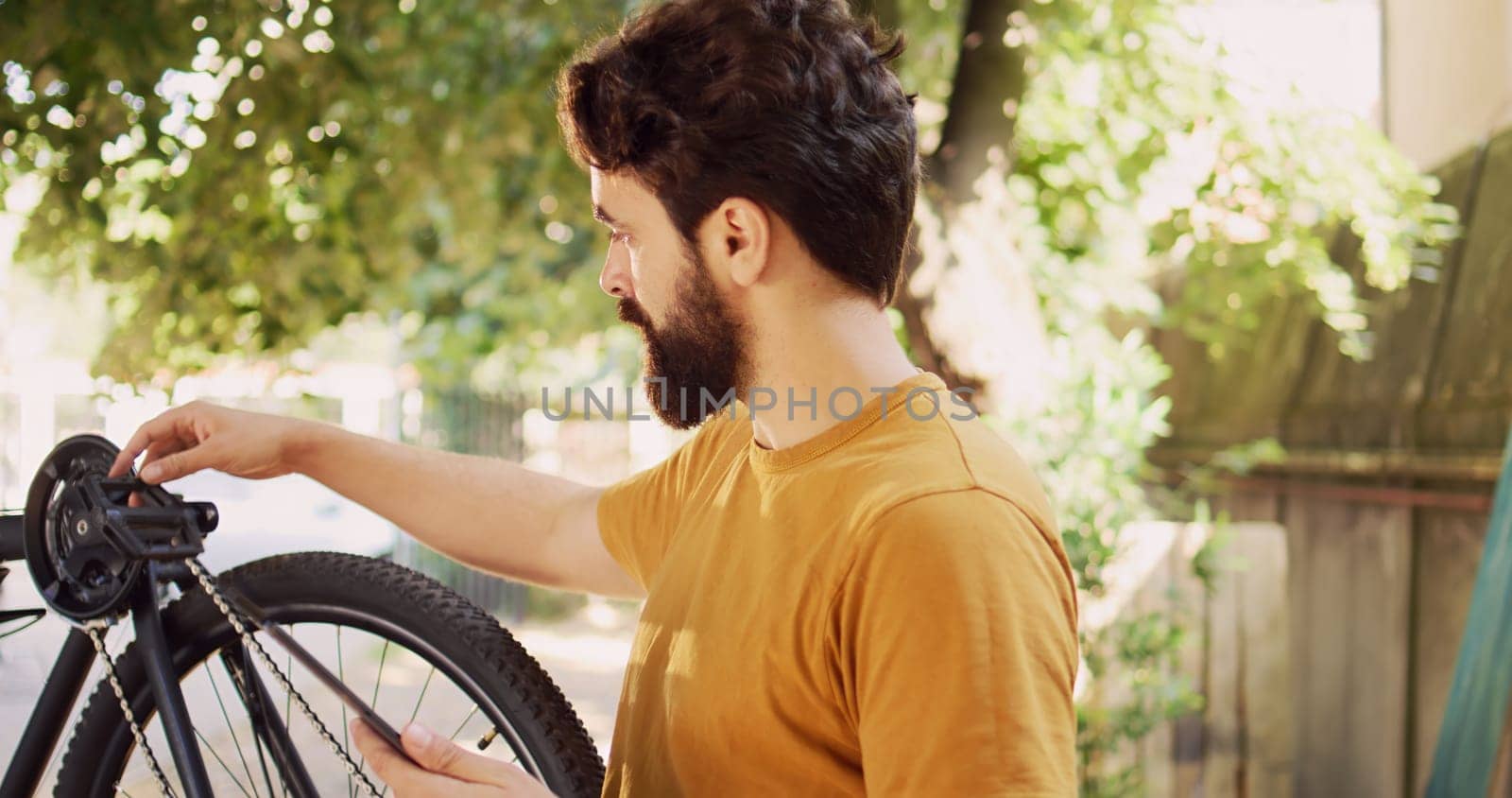 Man maintaining bicycle with tablet by DCStudio
