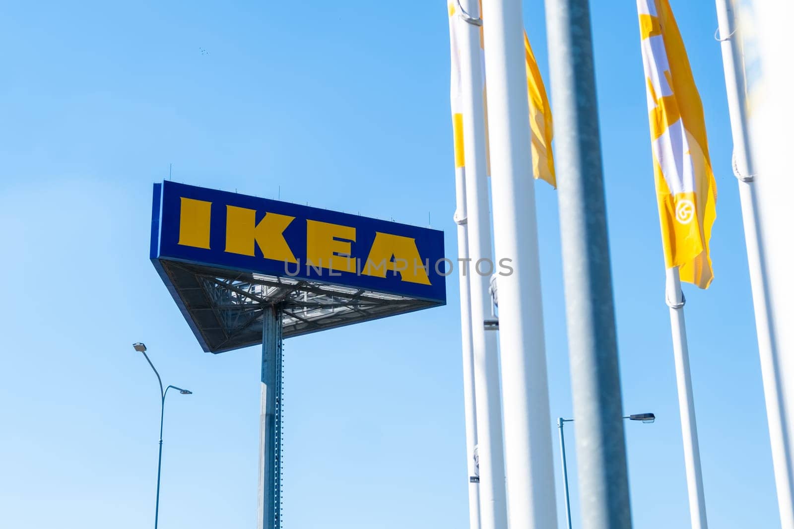 PRAGUE, CZECHIA -APRIL, 2024: IKEA logo against blue sky and flags.