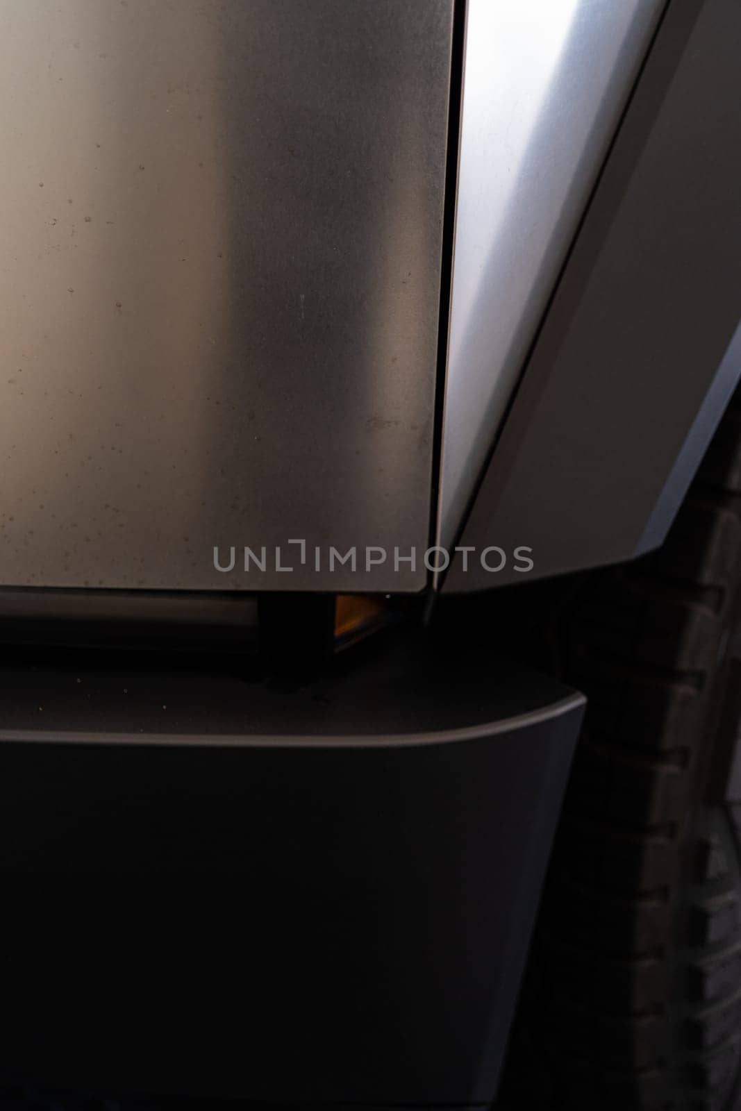 Denver, Colorado, USA-May 5, 2024-This image showcases the seamless design and sturdy architecture of the Tesla Cybertruck, featuring a detailed view of the side panel and tire, emphasizing the vehicle unique and innovative structure.