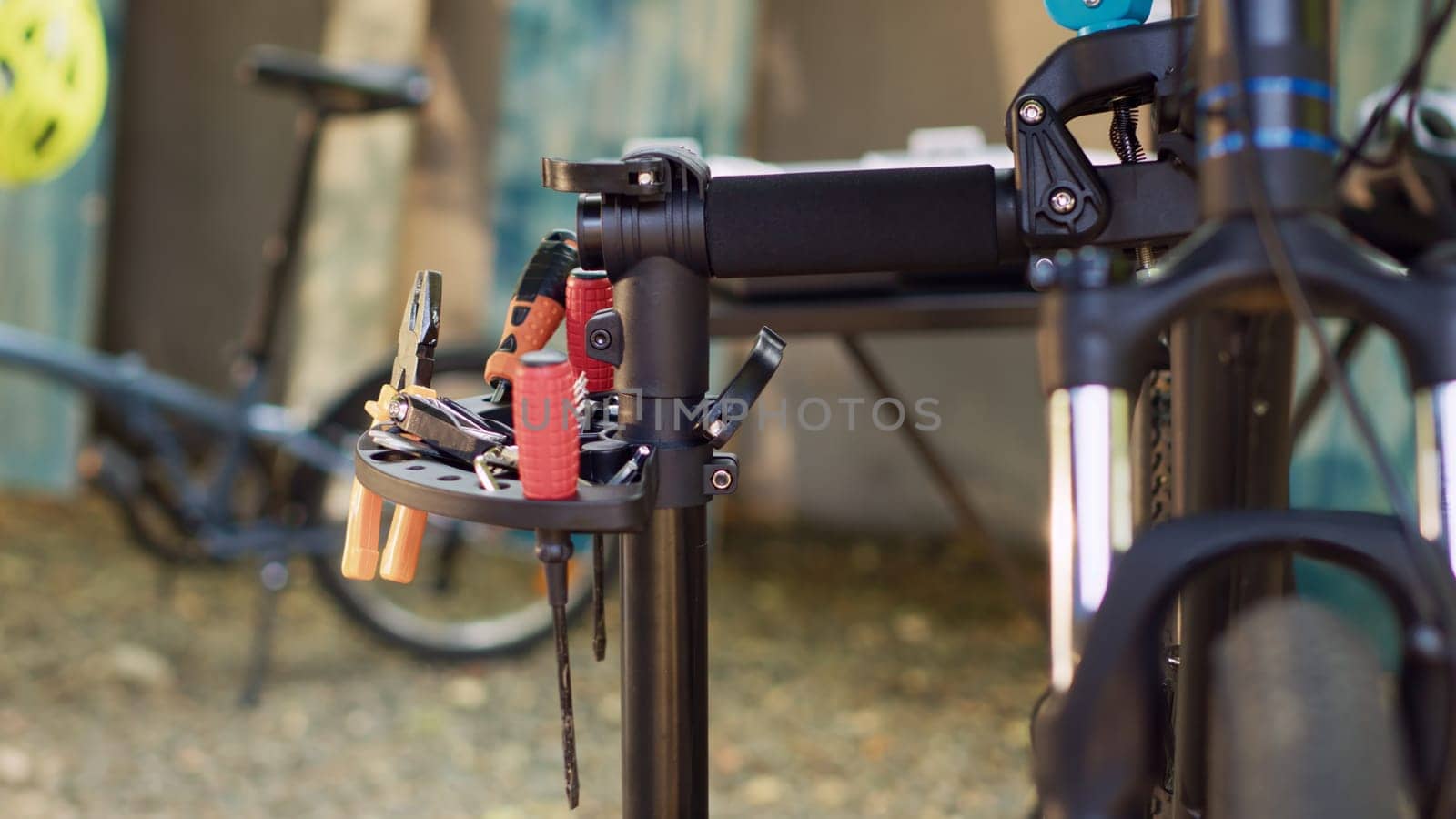 An assortment of professional equipment arranged on repair-stand ready for bike maintenance. Zoom-in shot of different work tools for bicycle repair and restoration in yard.