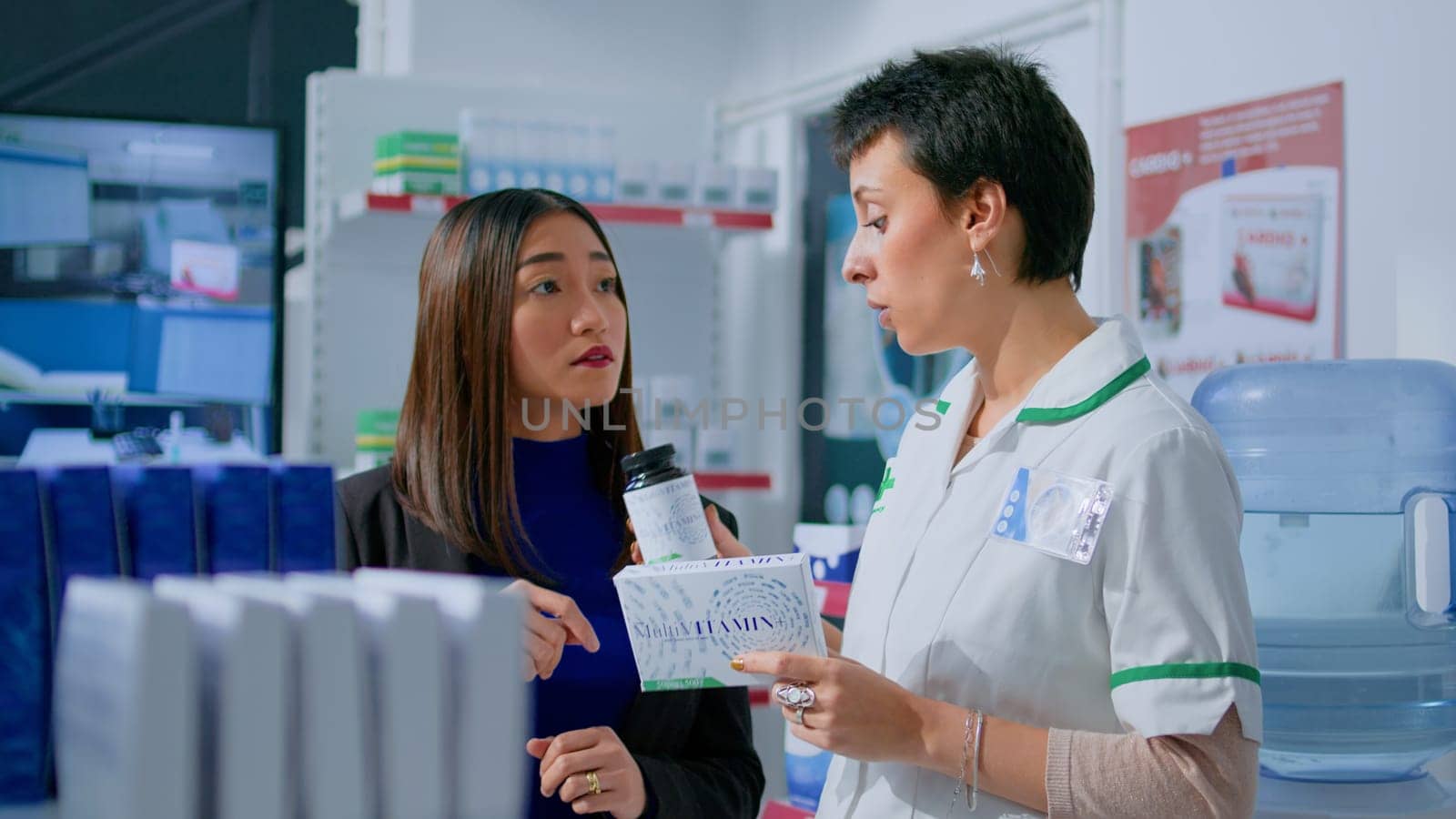 Customer in chemist store asking pharmacist for medical opinion, needing treatment for headache. Certified druggist helping client choose best pharmaceutical cure for her illness
