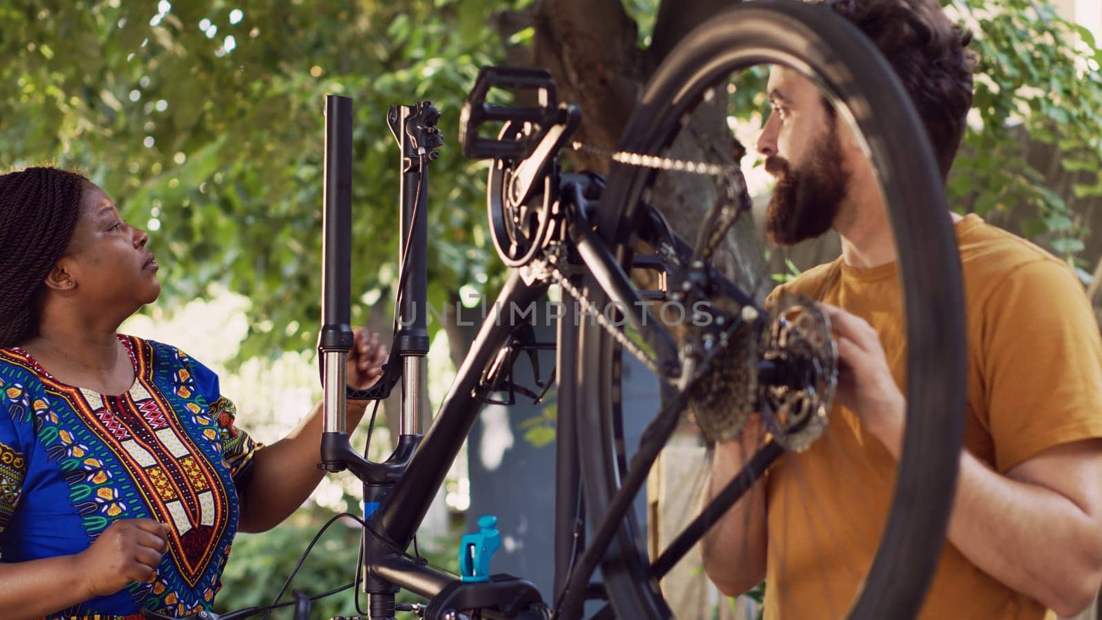 Multiracial pair inspects broken bicycle by DCStudio