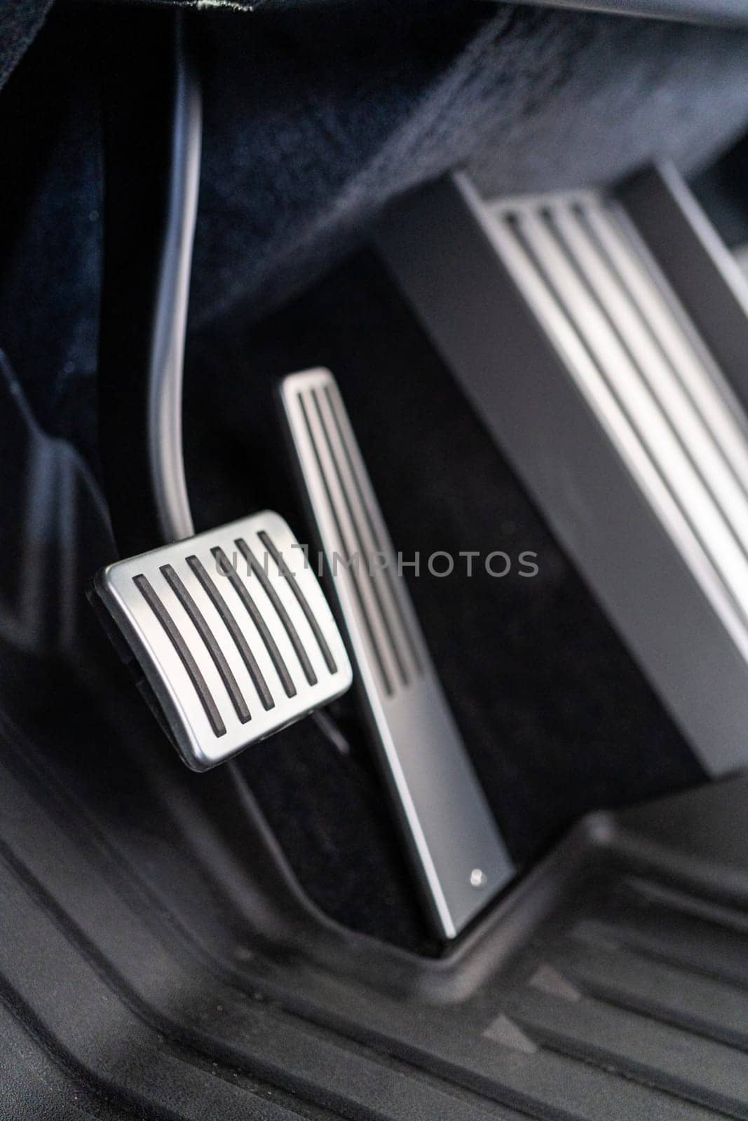 Denver, Colorado, USA-May 5, 2024-This image features a close-up view of the aluminum accelerator and brake pedals alongside the metal floor mat in a Tesla Cybertruck, highlighting the vehicle sleek and modern interior design.