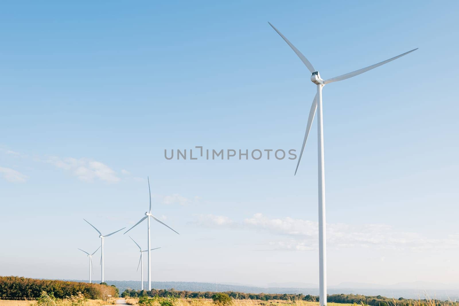 Nature meets technology, turbines on a mountain farm harness wind power for clean electricity. A modern windmill industry supporting sustainable development.