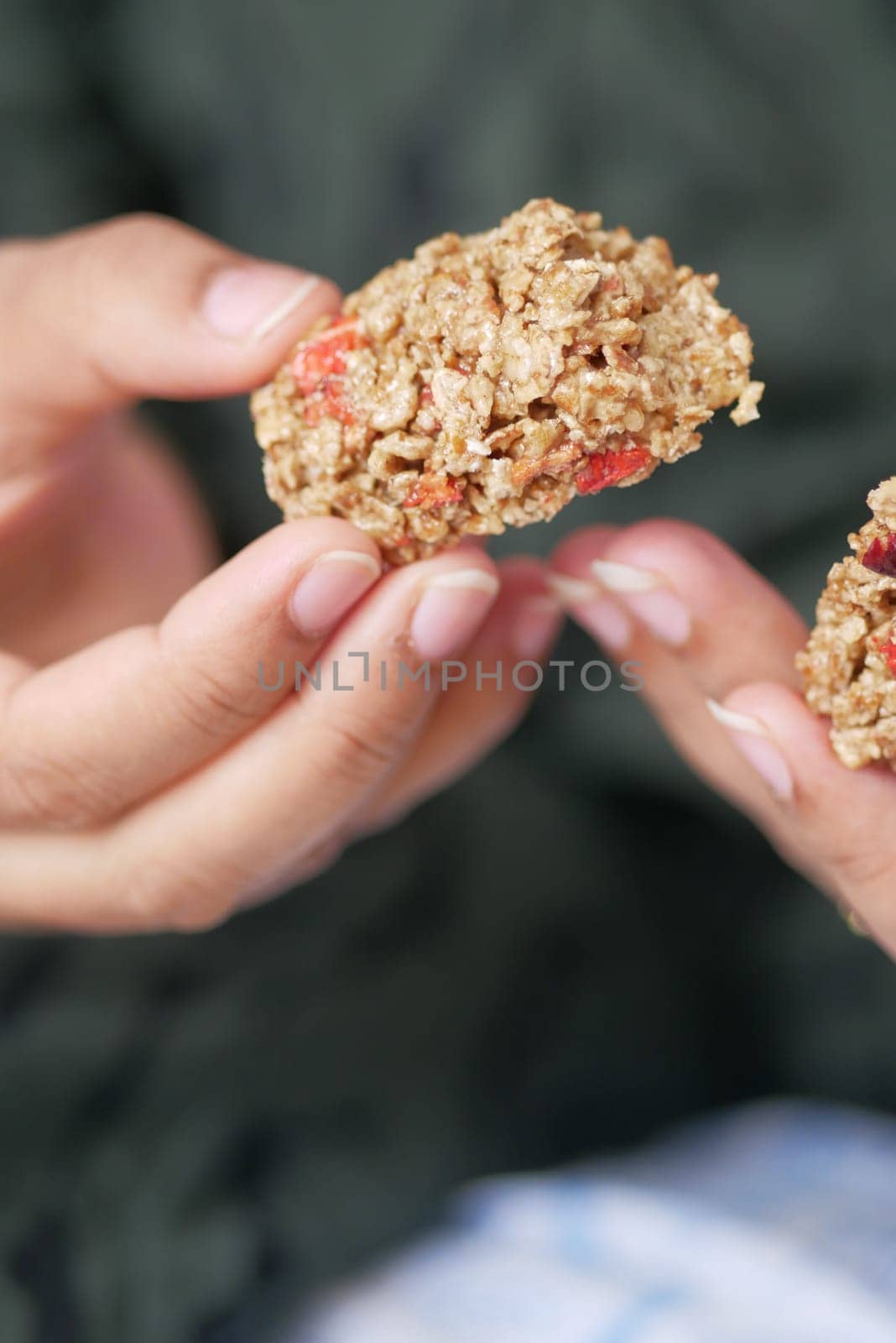 woman holding a Almond , Raisin and oat protein bar.
