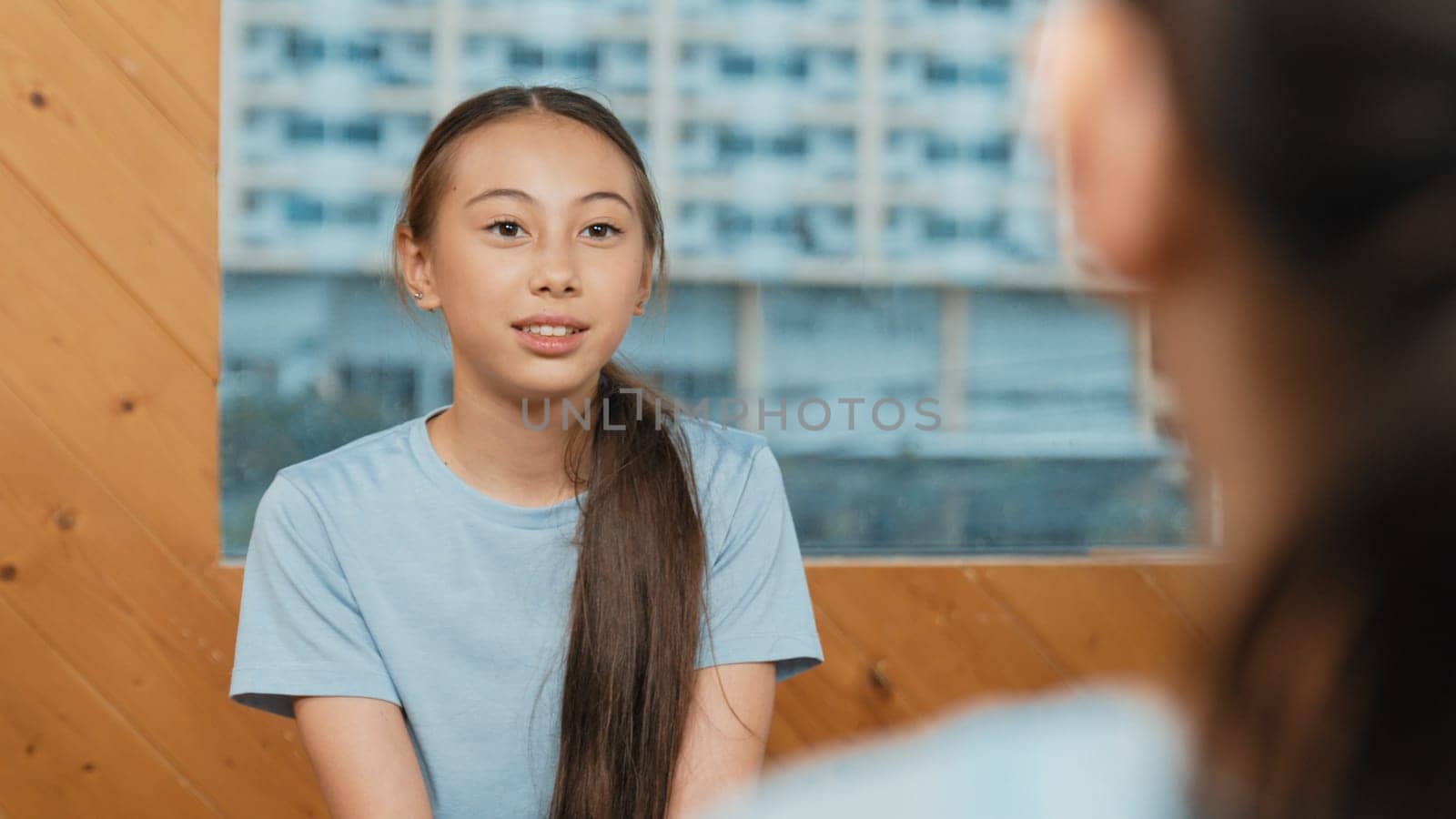 Young smart girl discussion about problem while sitting in circle. Skilled happy highschool student talking, brainstorming, sharing idea while diverse children listen and give comment. Edification.