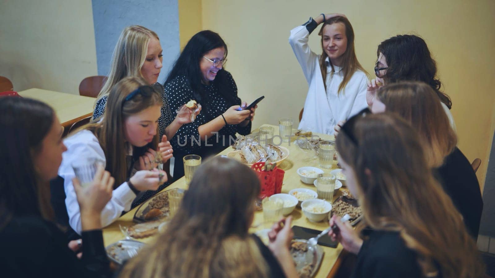 High school children eat in the school canteen. by DovidPro