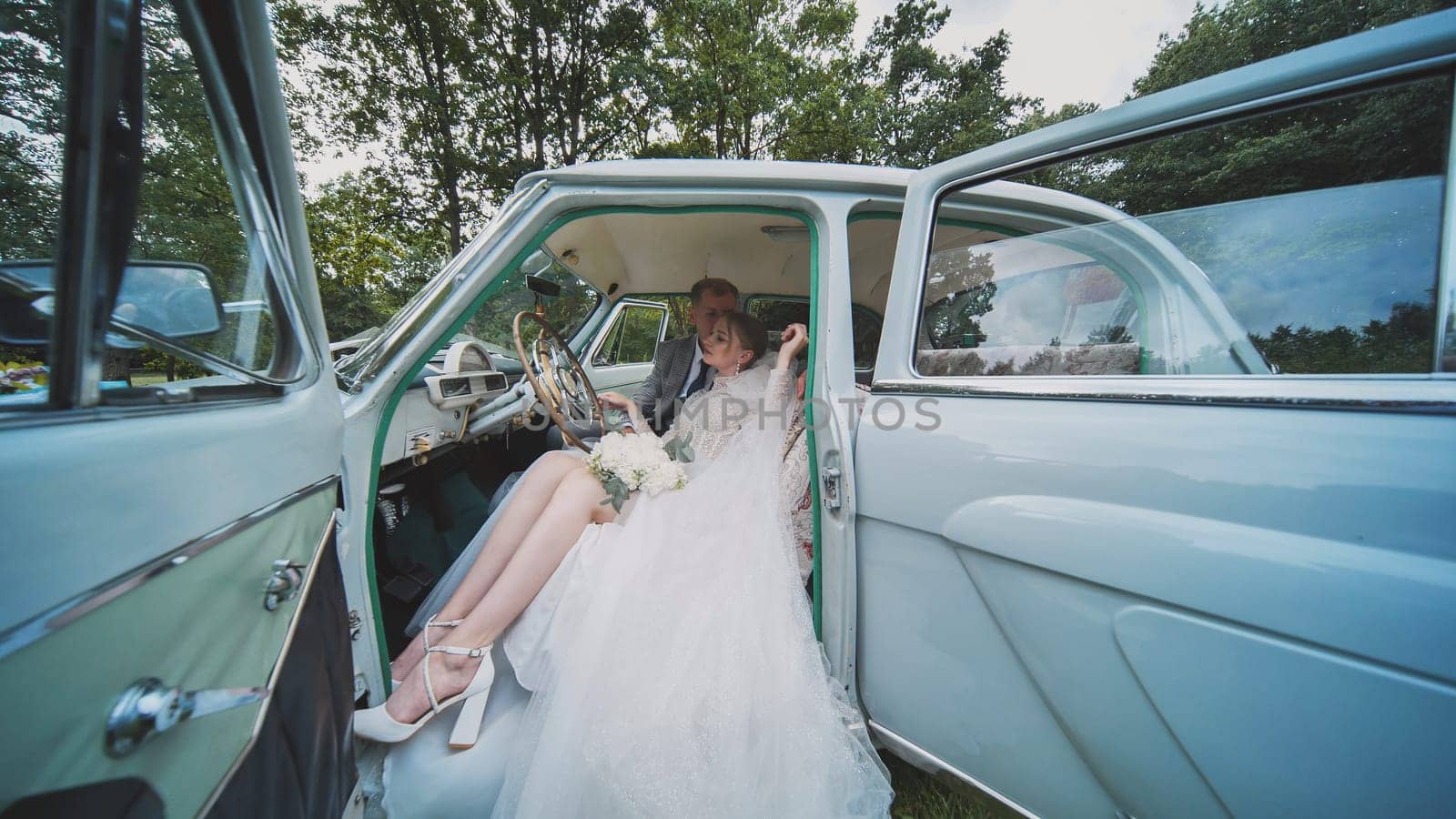 Bride and groom enjoying each other in a retro car