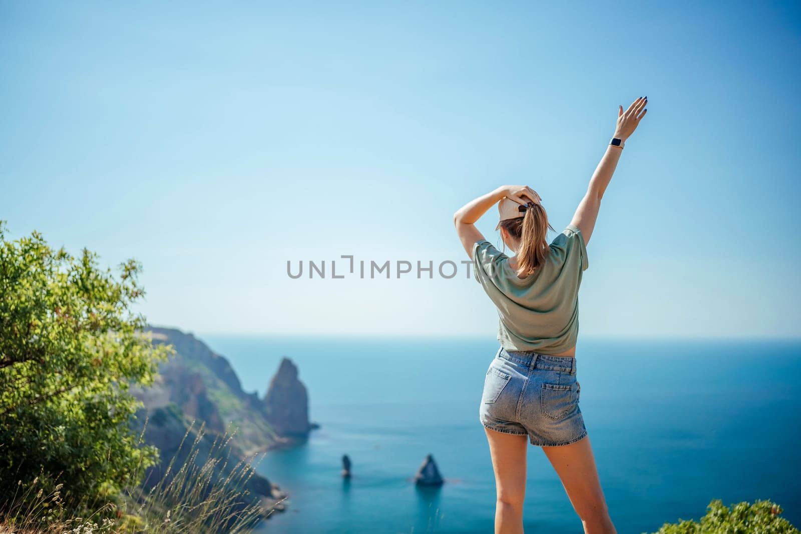 Woman tourist sky sea. Happy traveler woman in hat enjoys vacation raised her hands up by Matiunina