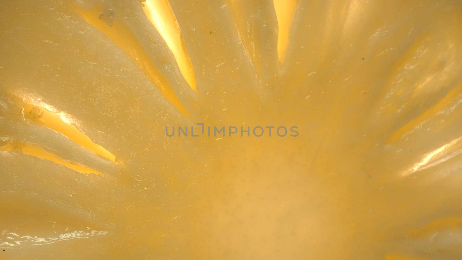 The pineapple slice, creating a sense of freshness. A close-up of a sliced pineapple reveals a tropical paradise. Sun-kissed yellow golden flesh with juice, contrasts the rough brown rind. Comestible.