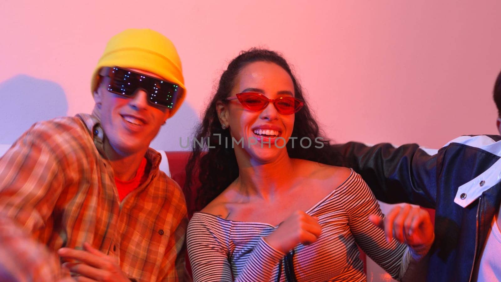 Close up of asian man and hispanic woman dancing together at party with led or neon light. Professional street dancer moving to freestyle and lively music while wear glasses and cloth. Regalement.