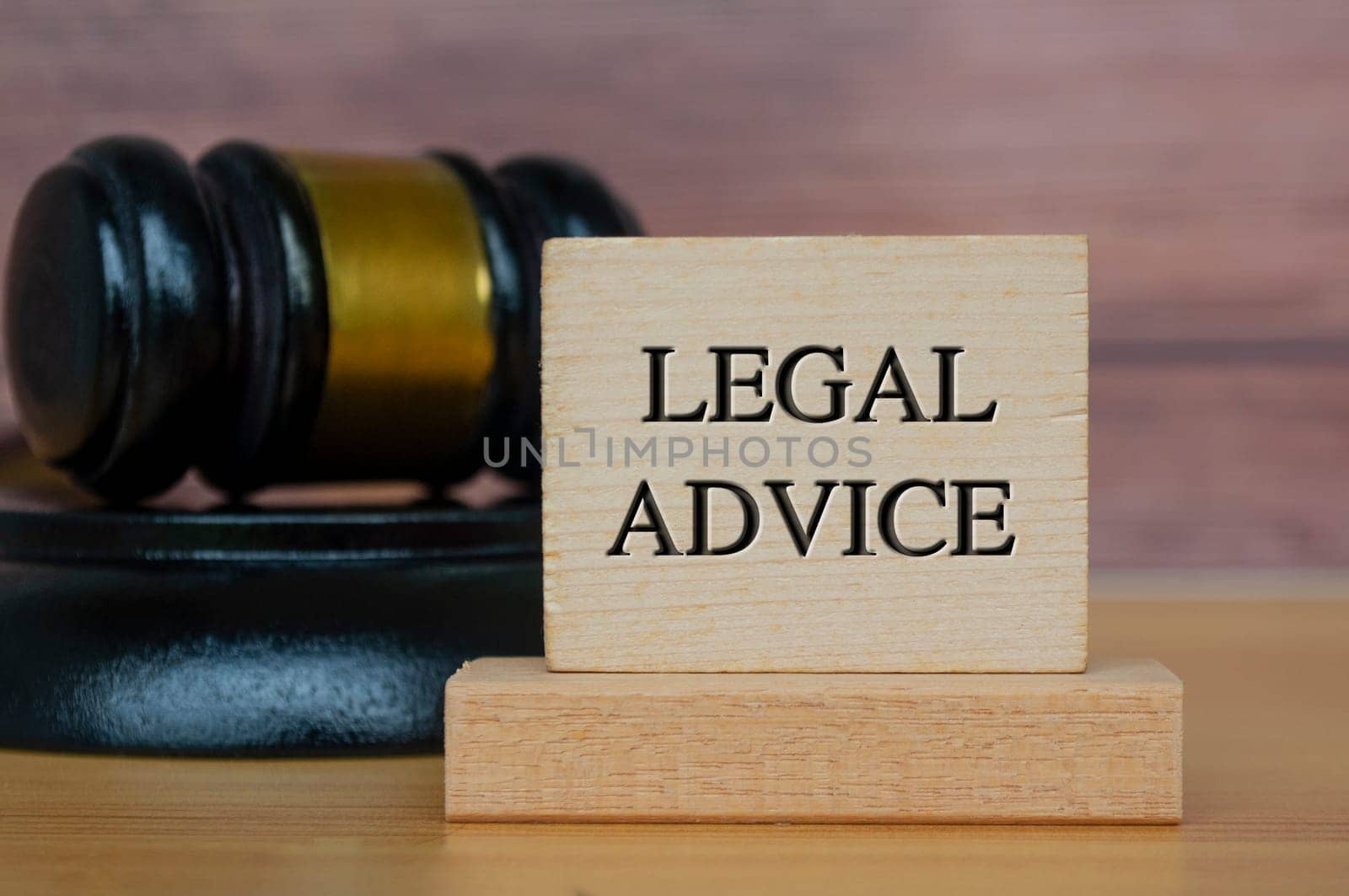 Legal advice text engraved on wooden block with gavel background. Legal and law concept