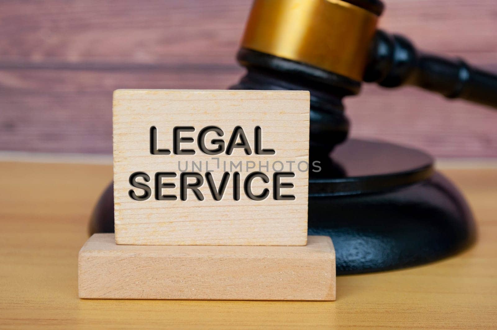 Legal service text engraved on wooden block with gavel background. Legal and law concept. by yom98