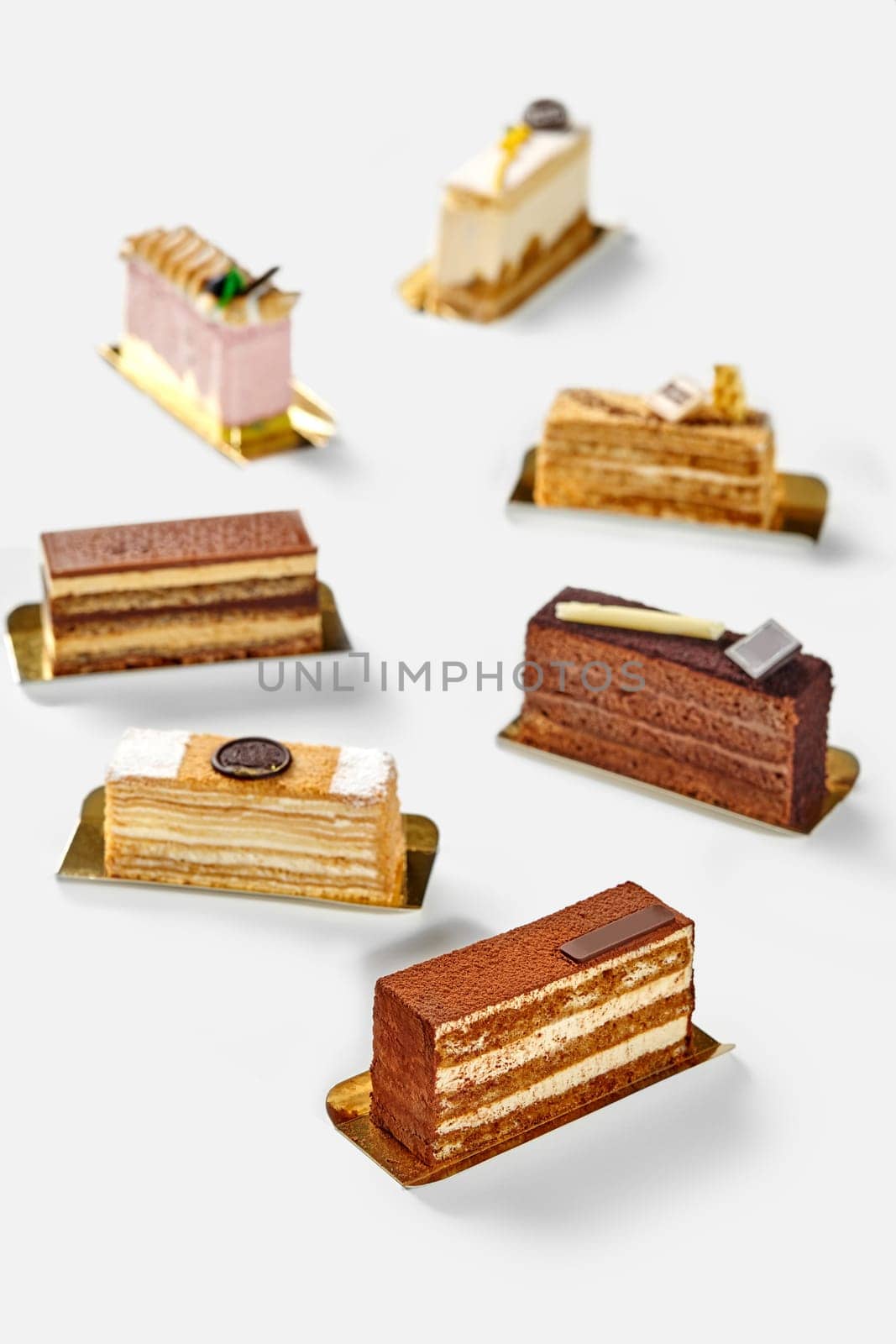 Slices of variety of exquisite cakes on white background by nazarovsergey