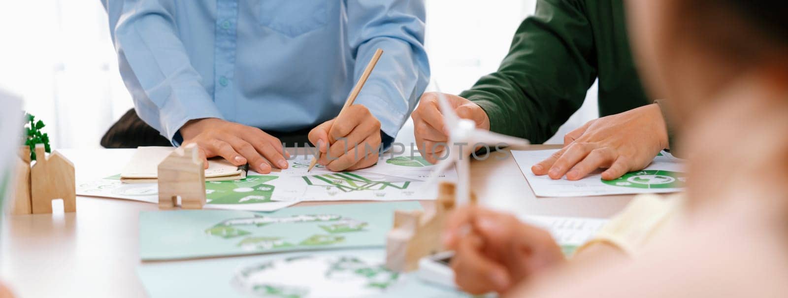 Green business meeting represented renewable energy. Skilled businesspeople discuss green business investment at table with environmental documents. Closeup. Focus on hand. Delineation.