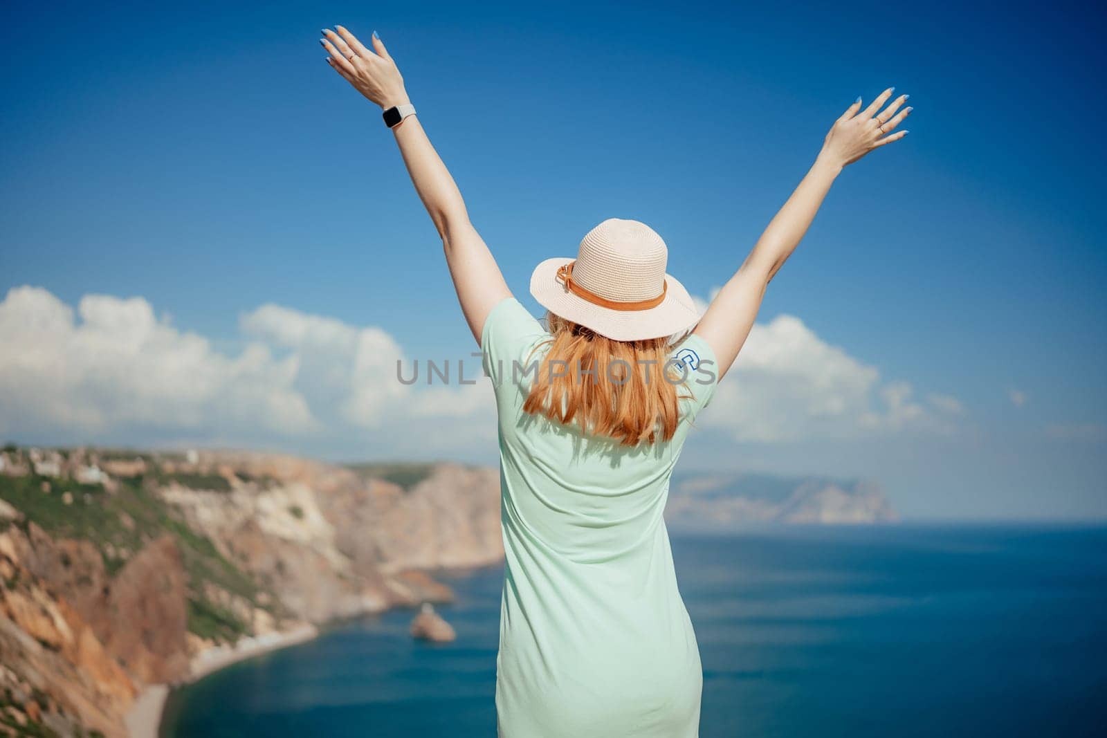 Woman tourist sky sea. Happy traveler woman in hat enjoys vacation raised her hands up by Matiunina