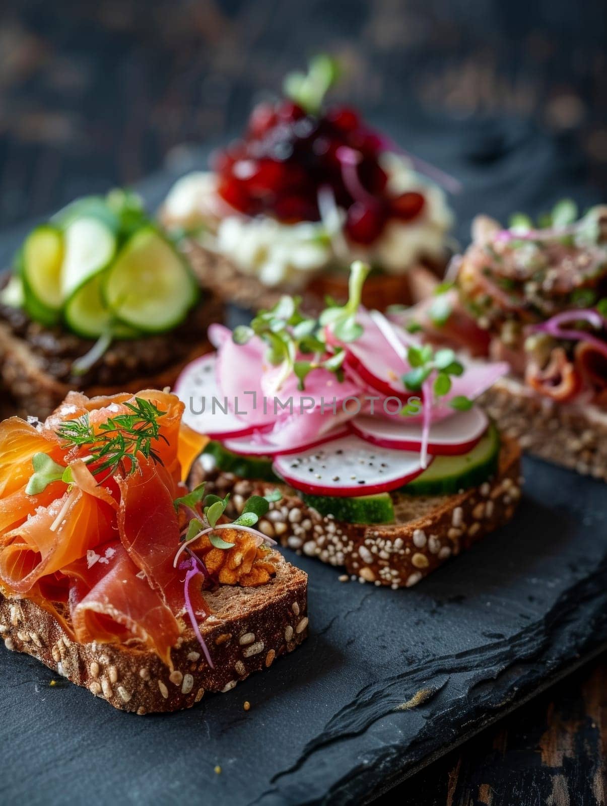 Danish smorrebrod, open-faced sandwiches with various toppings, served on a slate plate. A traditional and flavorful dish from Denmark